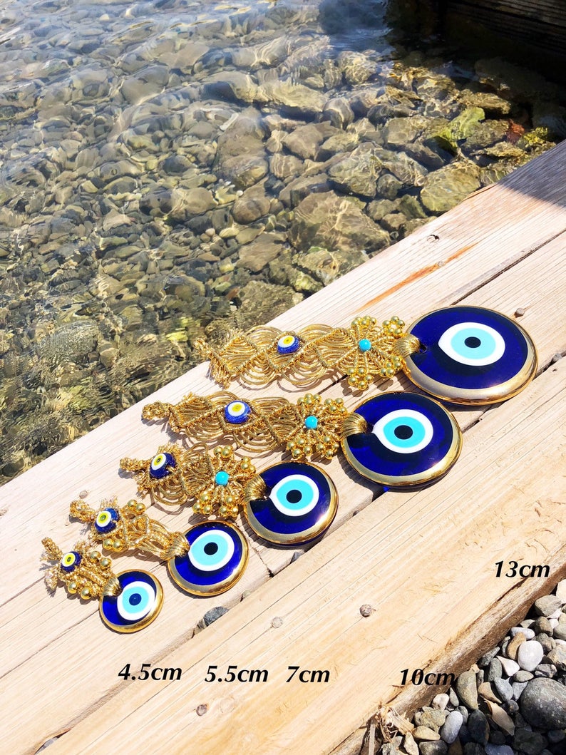 Gold macrame evil eye wall hanging featuring intricate designs and vibrant evil eye beads, symbolizing protection and good luck.