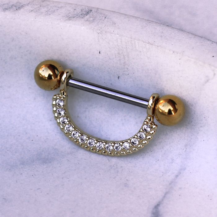 Gold plated ornate nipple shield adorned with multiple clear cubic zirconia stones, showcasing an elegant design.