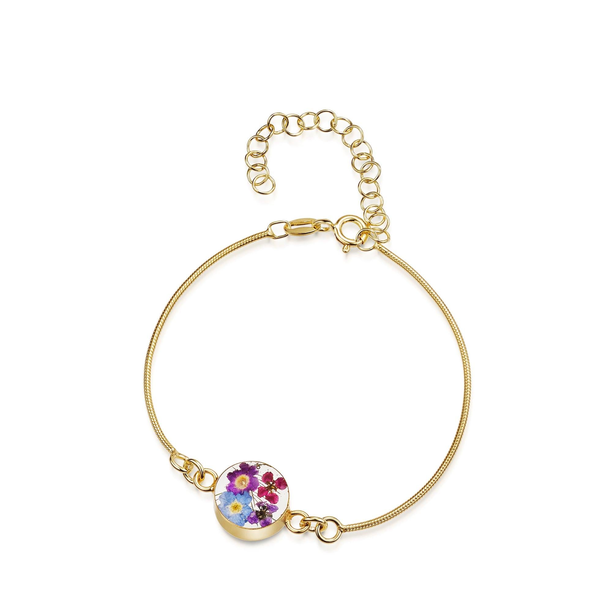 Gold plated snake bracelet featuring a handmade charm with real flowers set in resin, showcasing a delicate and elegant design.