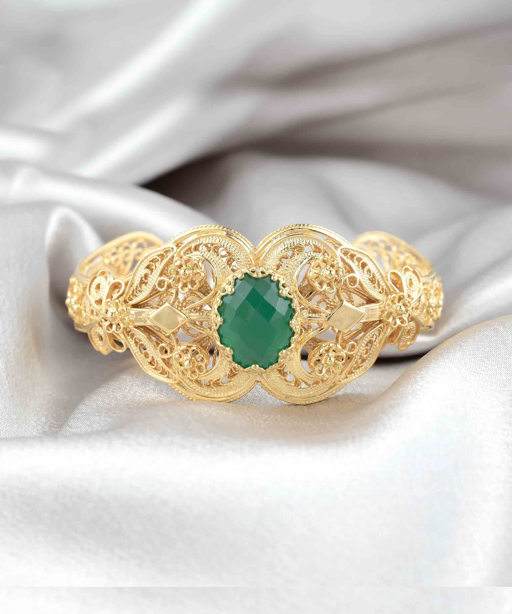 Gold plated sterling silver cuff bracelet featuring intricate filigree art and a double-sided faceted green agate gemstone.