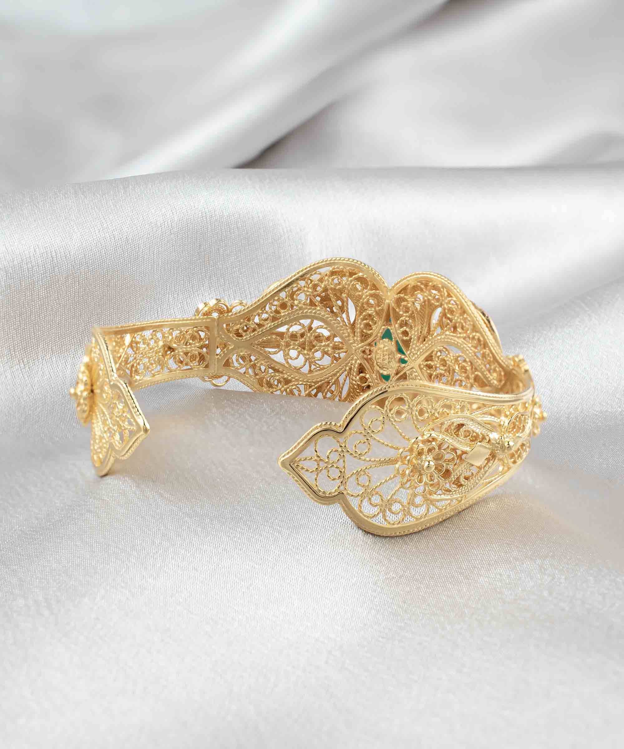 Gold plated sterling silver cuff bracelet featuring intricate filigree art and a double-sided faceted green agate gemstone.