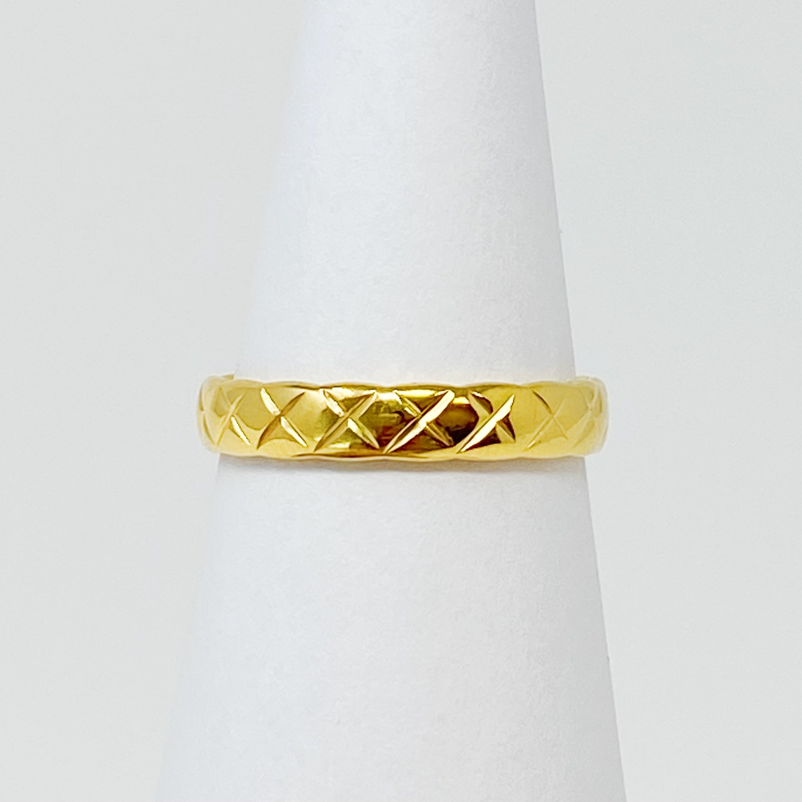 A stylish gold quilted ring made of stainless steel, featuring a textured surface, perfect for layering or wearing alone.