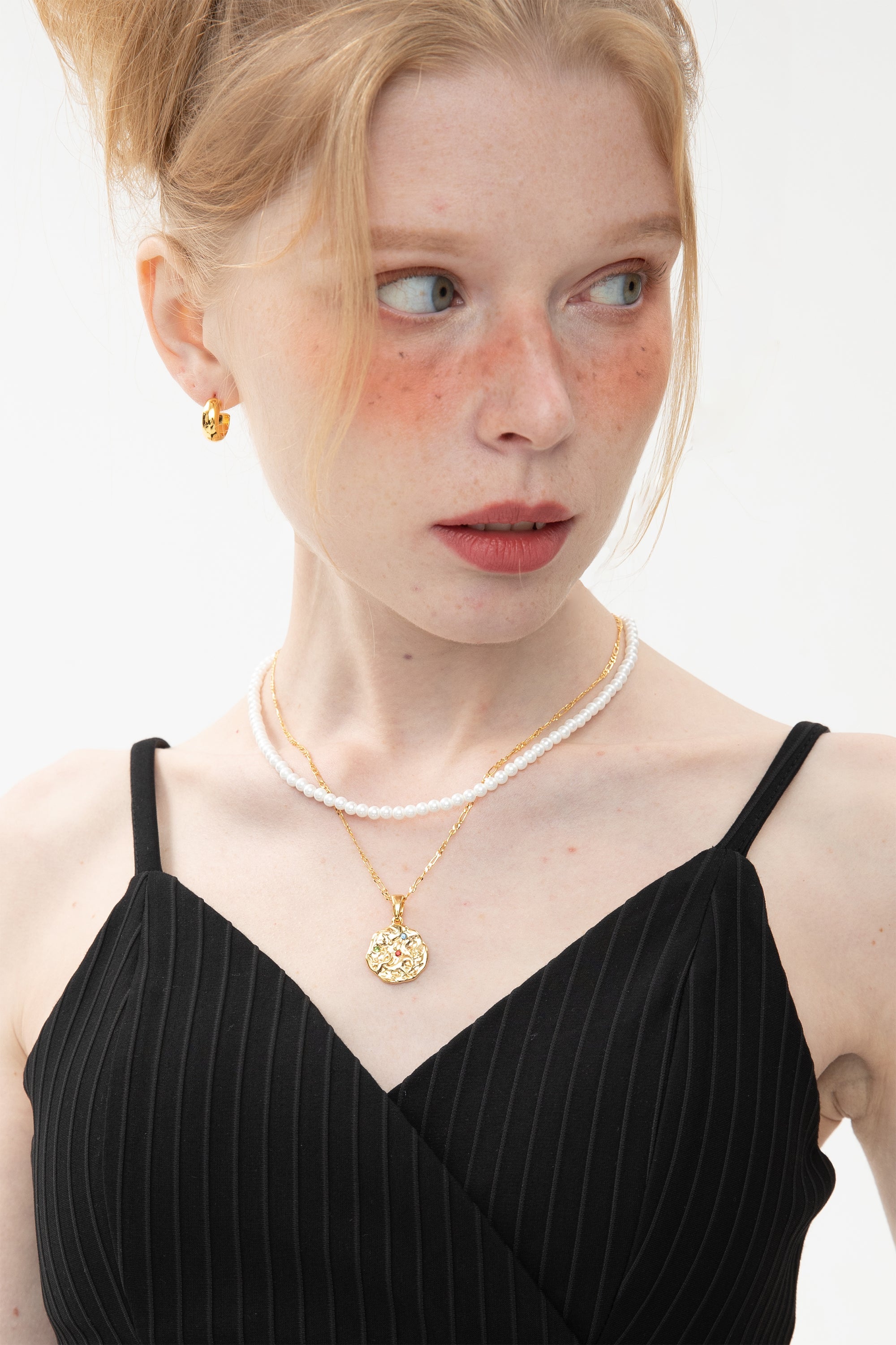 Gold Sculptural Zodiac Sign Pendant Necklace Set featuring an engraved zodiac charm, pearl necklace, and gold figaro chain.