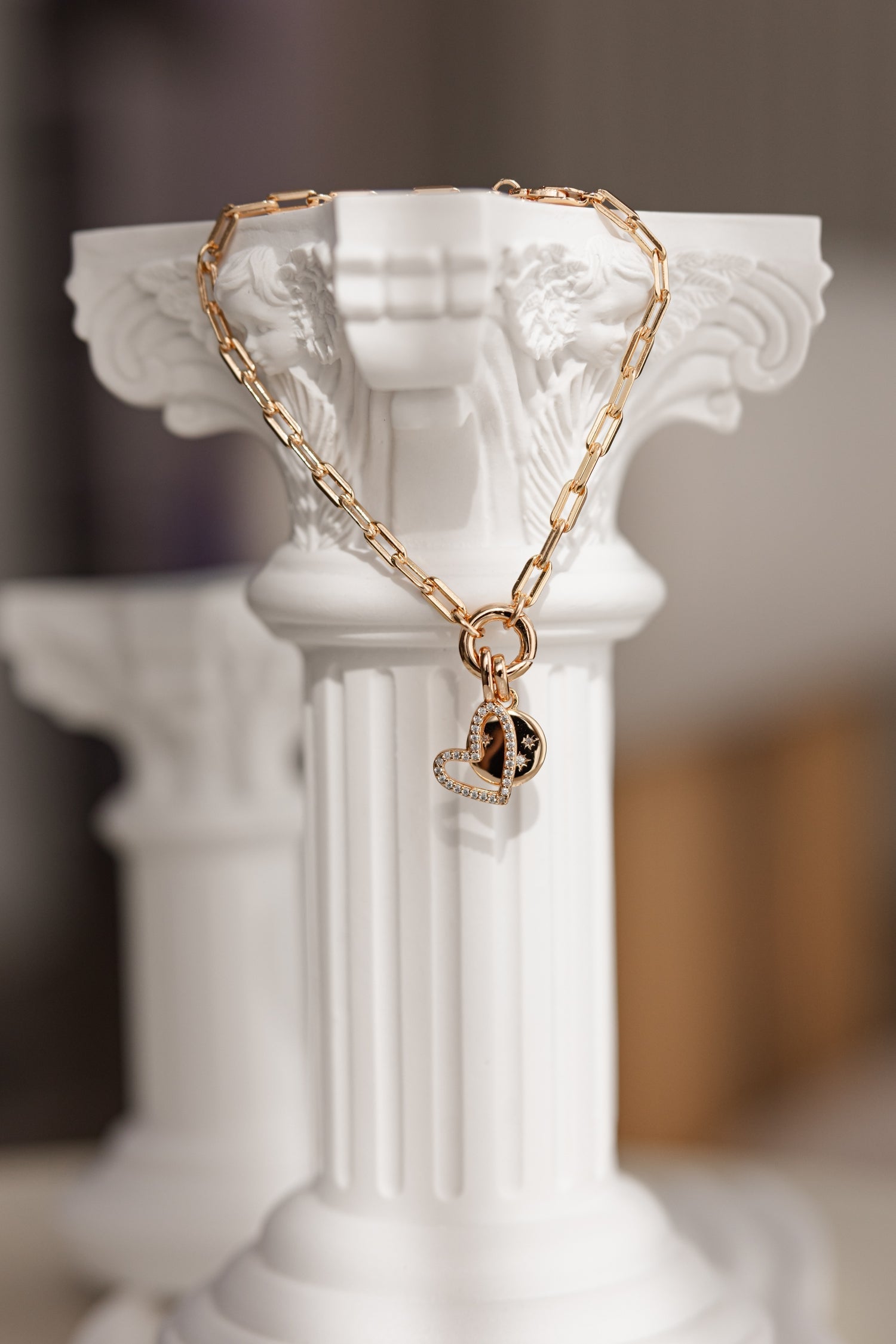 A luxurious Gold Stardust Bracelet featuring a charm carrier and a sparkling Round Stardust Charm, elegantly displayed on a soft surface.