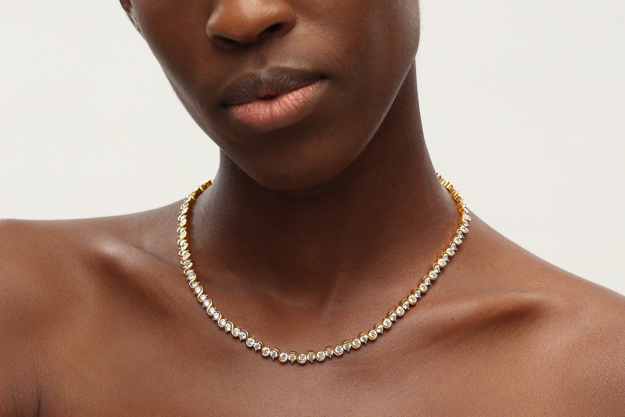 Elegant Gold Wave Zirconia Tennis Choker Necklace with sparkling cubic zirconia stones set in 18K gold plated brass.