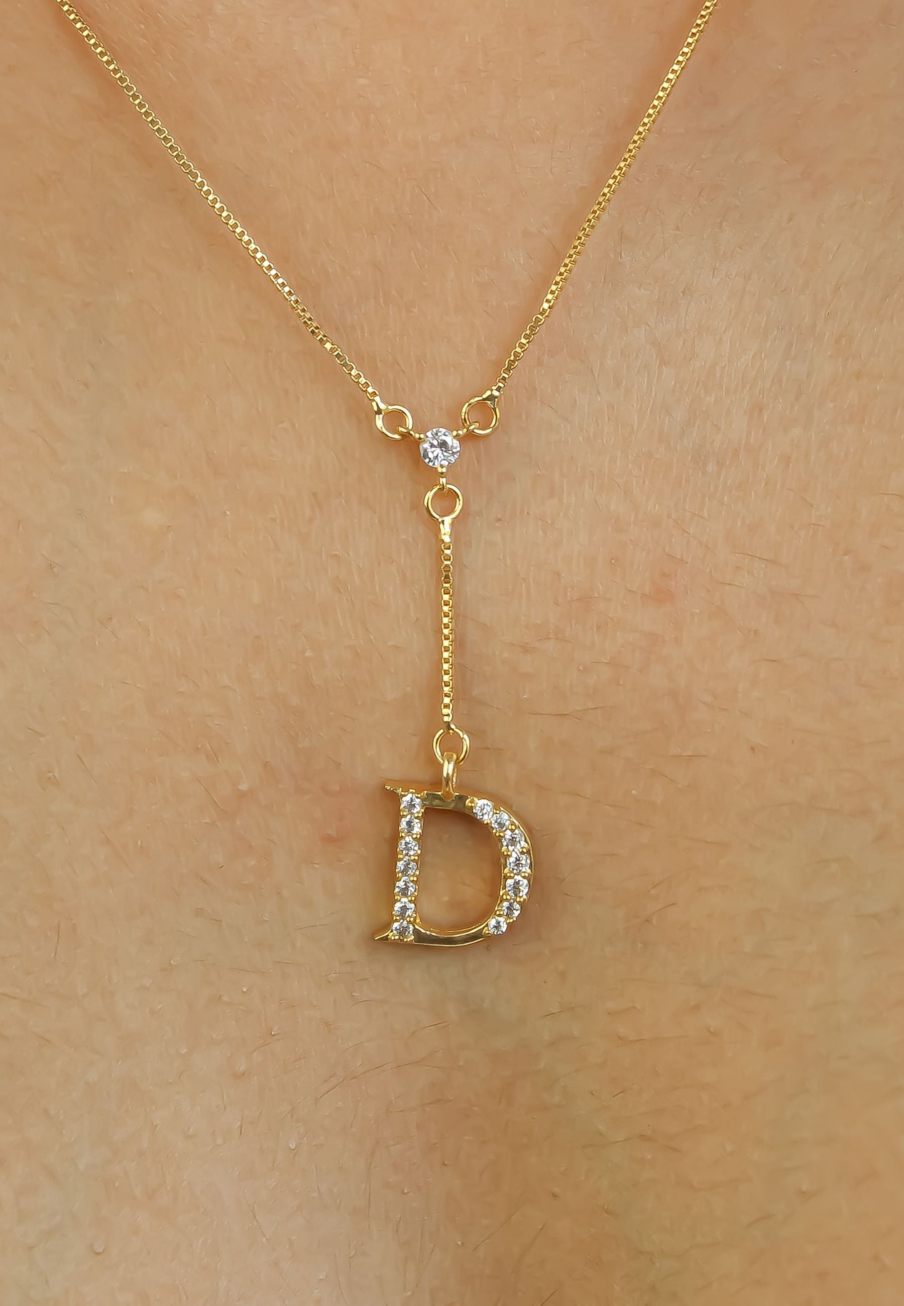 Elegant Golden Alphabet Necklace with zirconia stones, showcasing a personalized initial, perfect for layering or gifting.