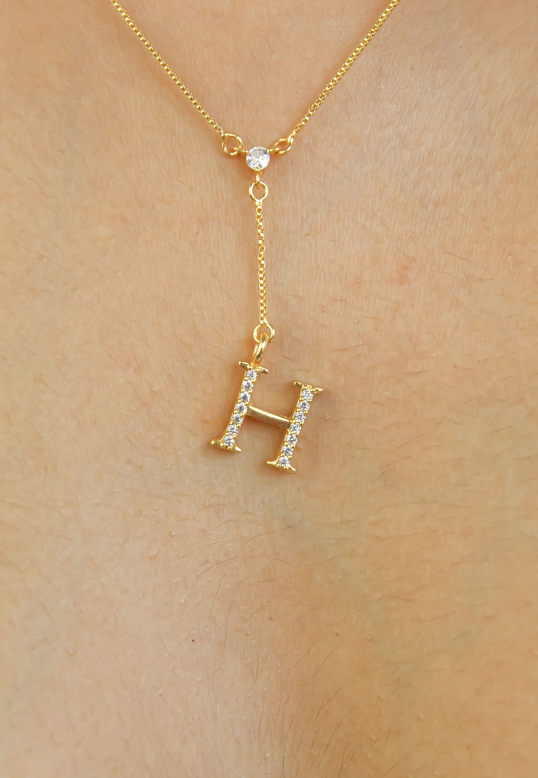 Elegant Golden Alphabet Necklace with zirconia stones, showcasing a personalized initial, perfect for layering or gifting.