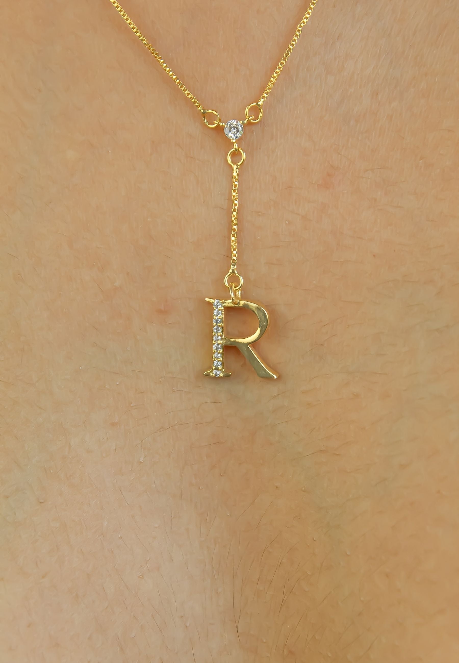 Elegant Golden Alphabet Necklace with zirconia stones, showcasing a personalized initial, perfect for layering or gifting.