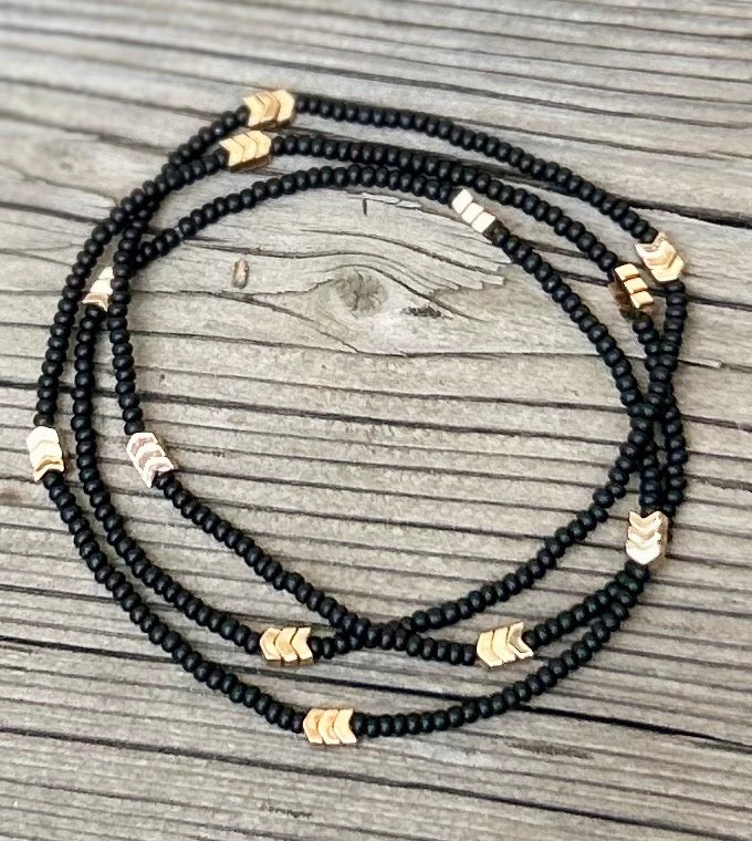 Golden Arrow Black 3-Wrap Boho Beaded Bracelet featuring jet black Czech glass beads and gold hematite accents, elegantly wrapped around a wrist.