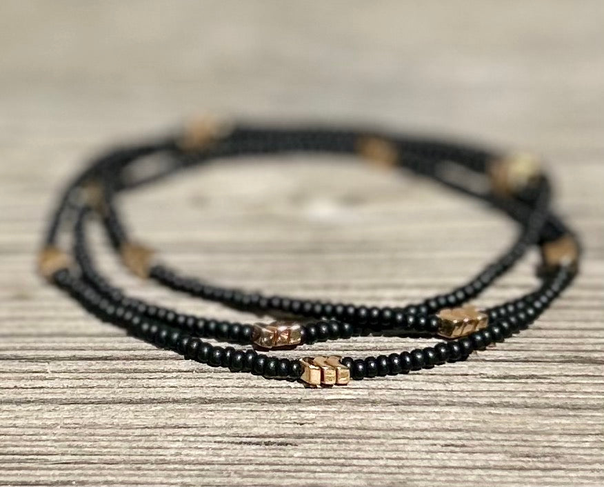 Golden Arrow Black 3-Wrap Boho Beaded Bracelet featuring jet black Czech glass beads and gold hematite accents, elegantly wrapped around a wrist.