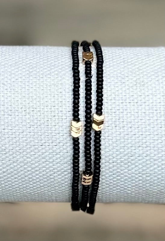 Golden Arrow Black 3-Wrap Boho Beaded Bracelet featuring jet black Czech glass beads and gold hematite accents, elegantly wrapped around a wrist.