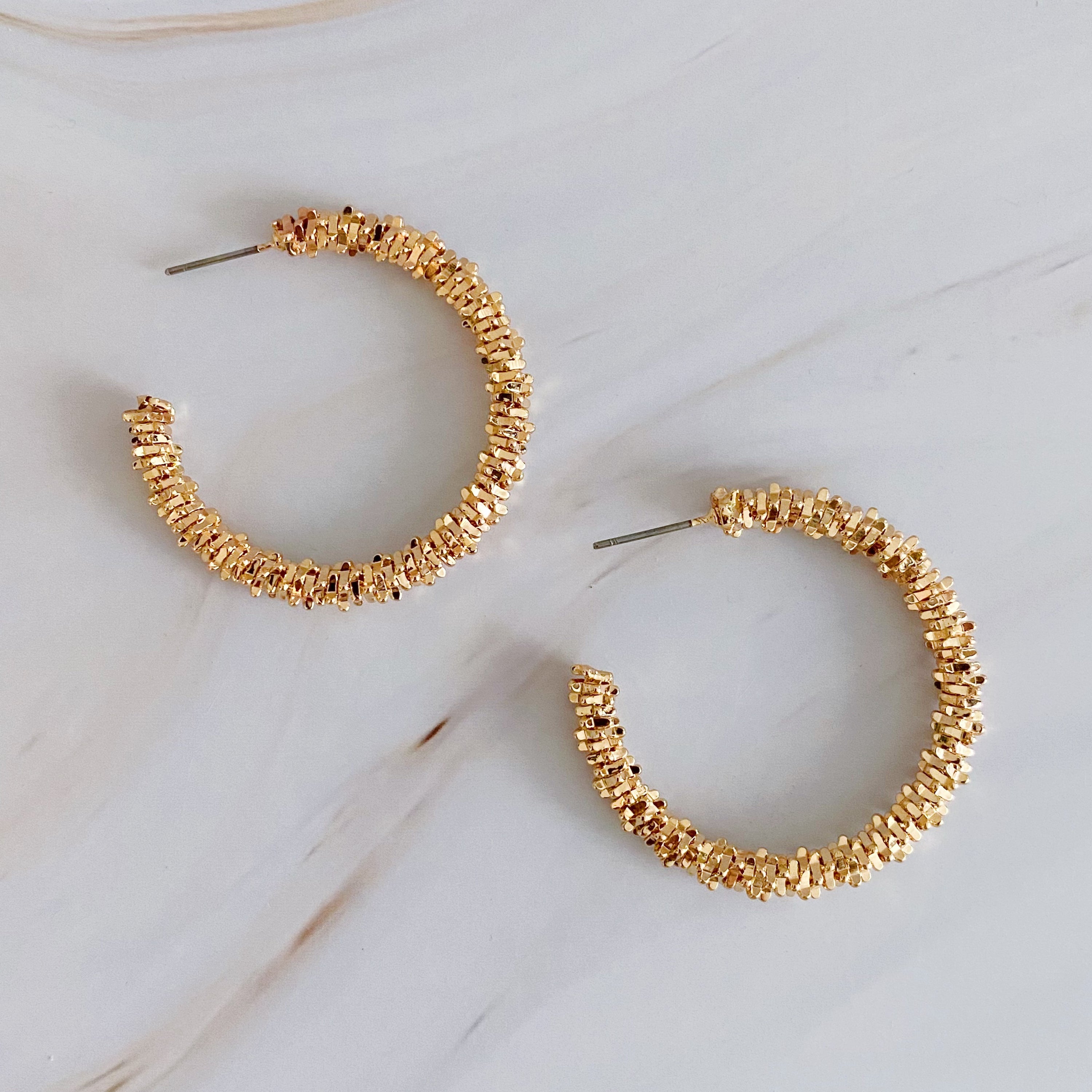 Elegant Golden Pebbles Hoop Earrings featuring small faceted metal pieces, reflecting light beautifully.