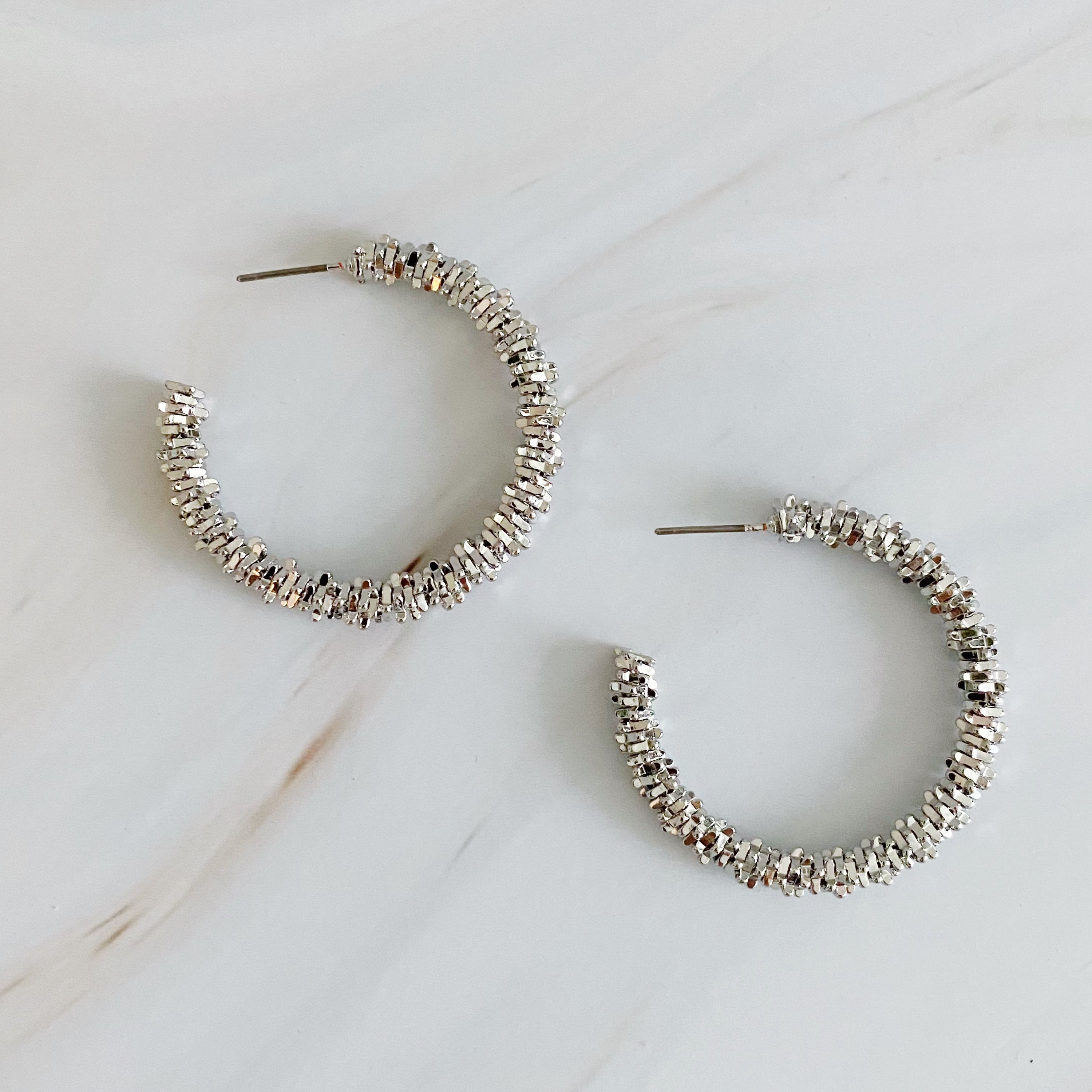 Elegant Golden Pebbles Hoop Earrings featuring small faceted metal pieces, reflecting light beautifully.