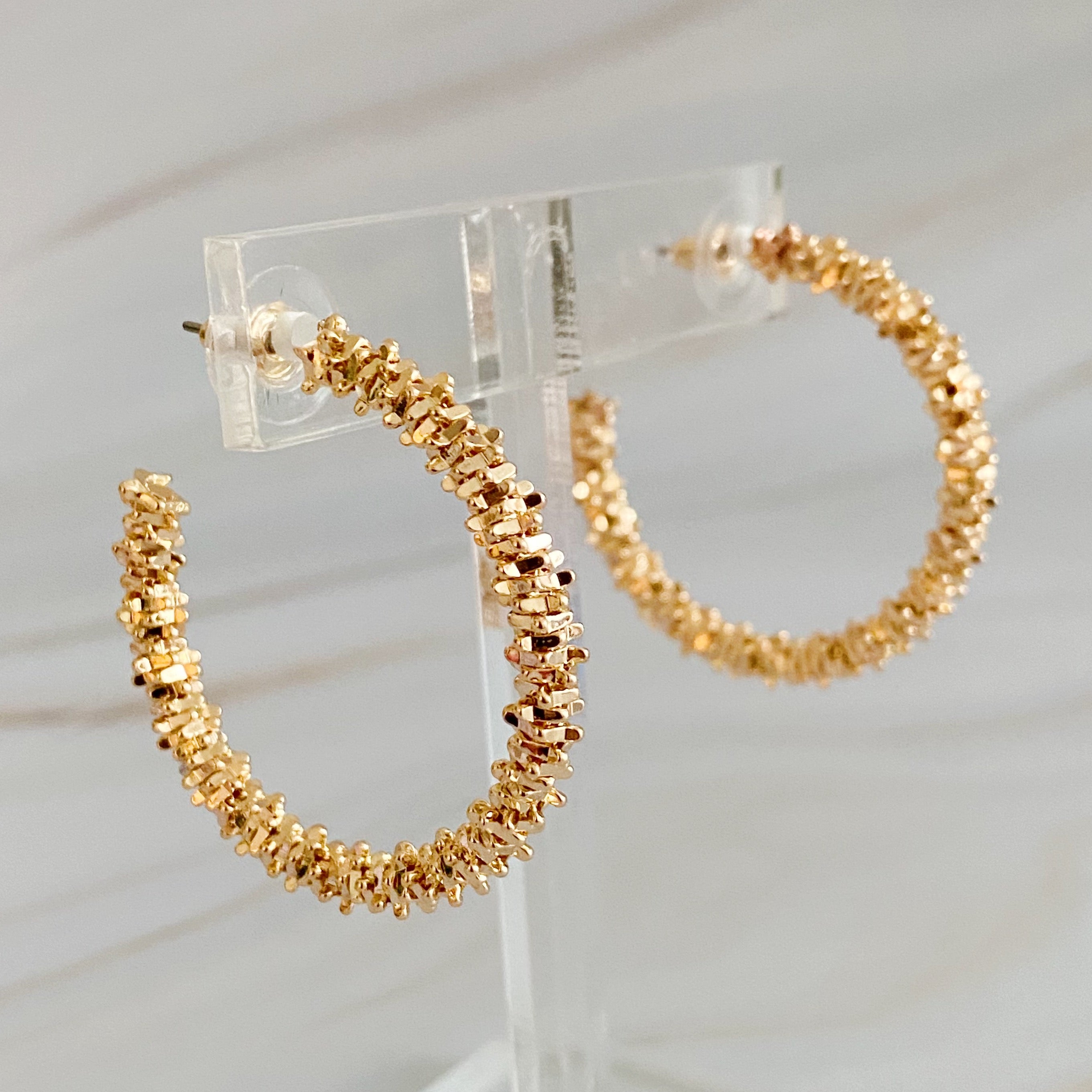 Elegant Golden Pebbles Hoop Earrings featuring small faceted metal pieces, reflecting light beautifully.