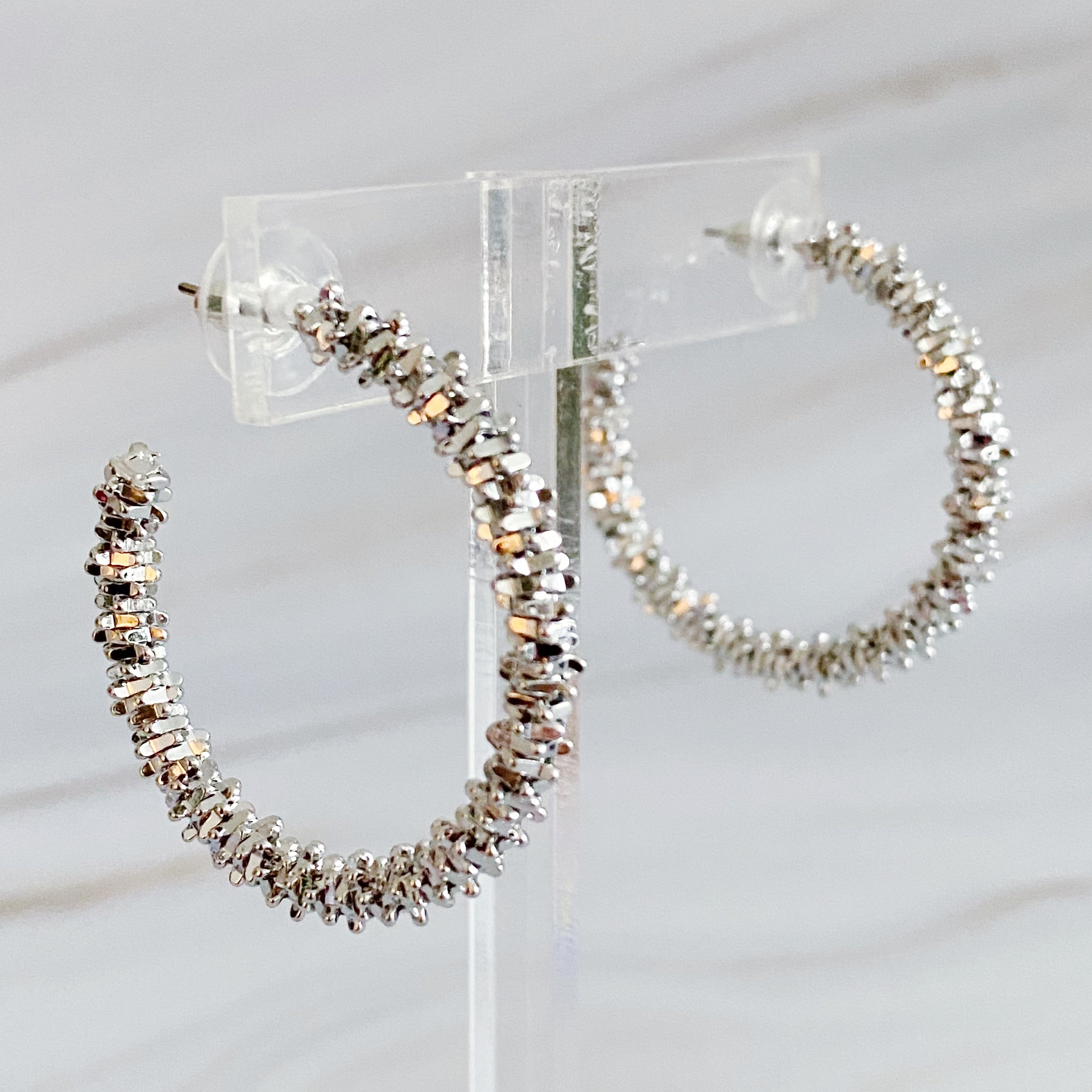 Elegant Golden Pebbles Hoop Earrings featuring small faceted metal pieces, reflecting light beautifully.