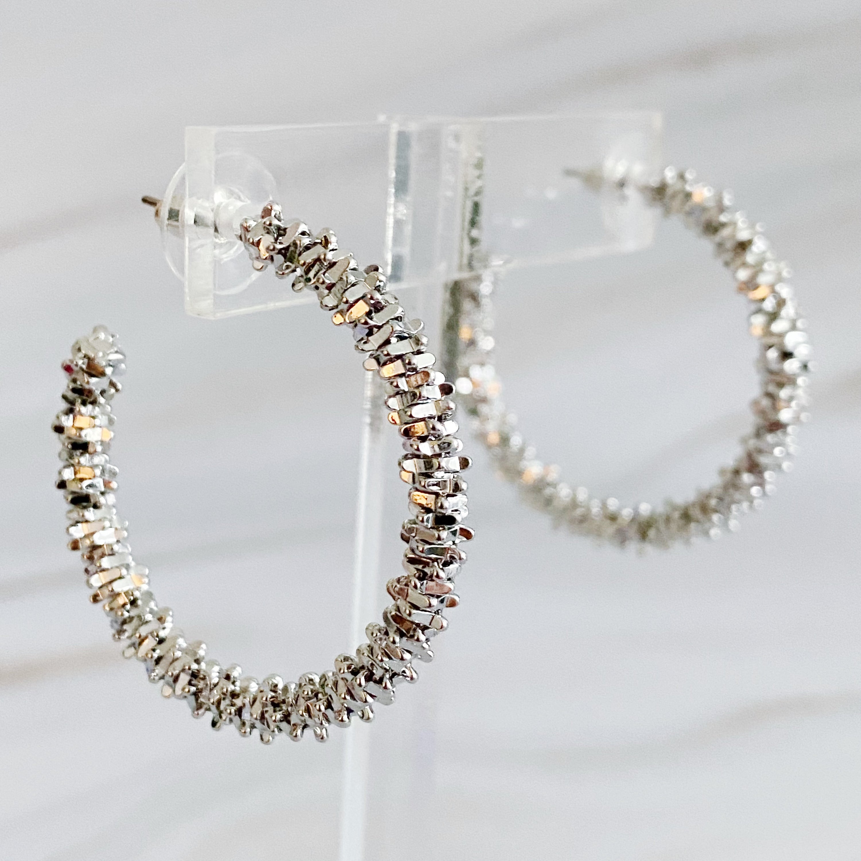 Elegant Golden Pebbles Hoop Earrings featuring small faceted metal pieces, reflecting light beautifully.