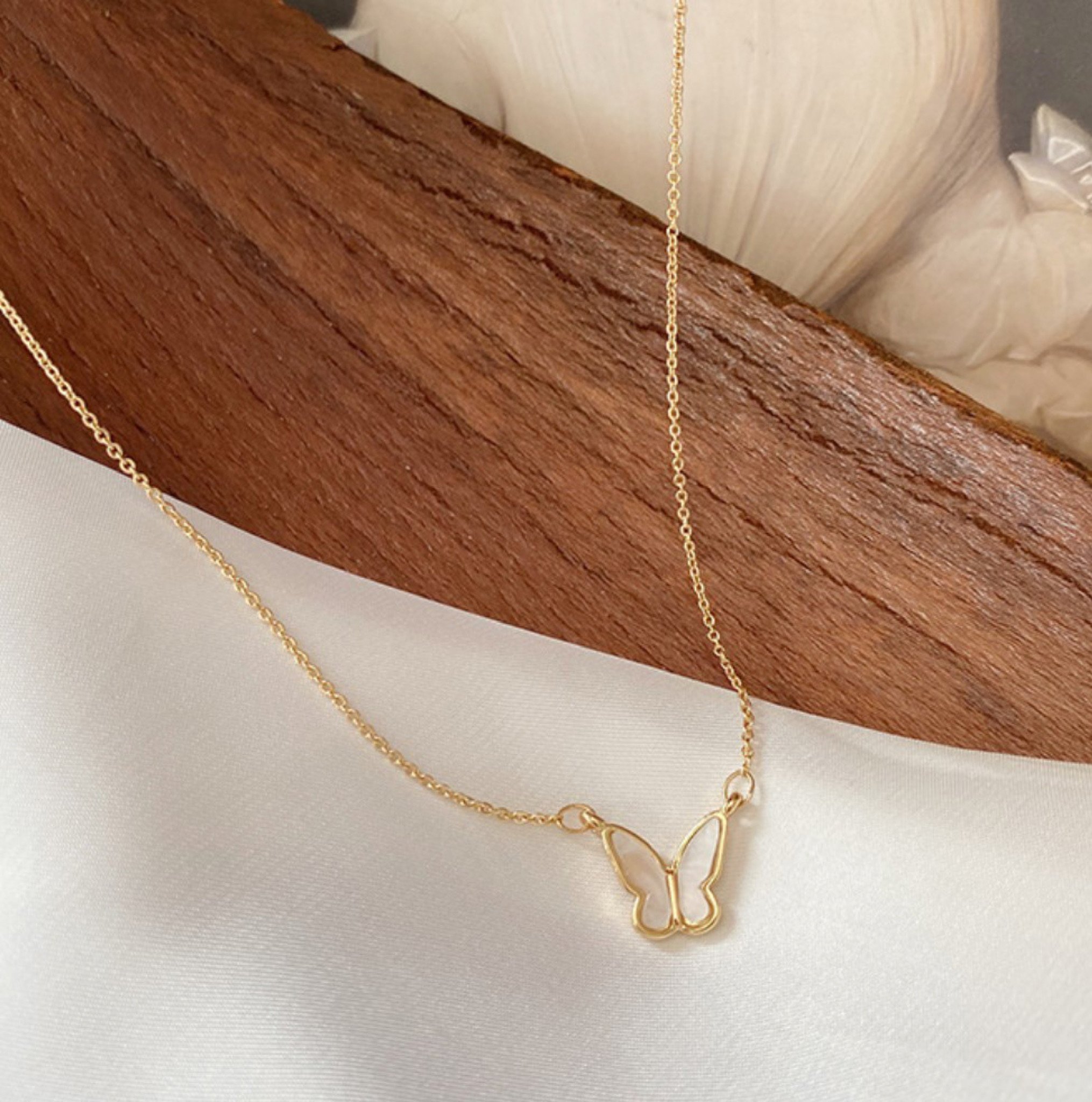 Golden Shell Butterfly Necklace featuring a white butterfly pendant on a stainless steel chain, perfect for layering.