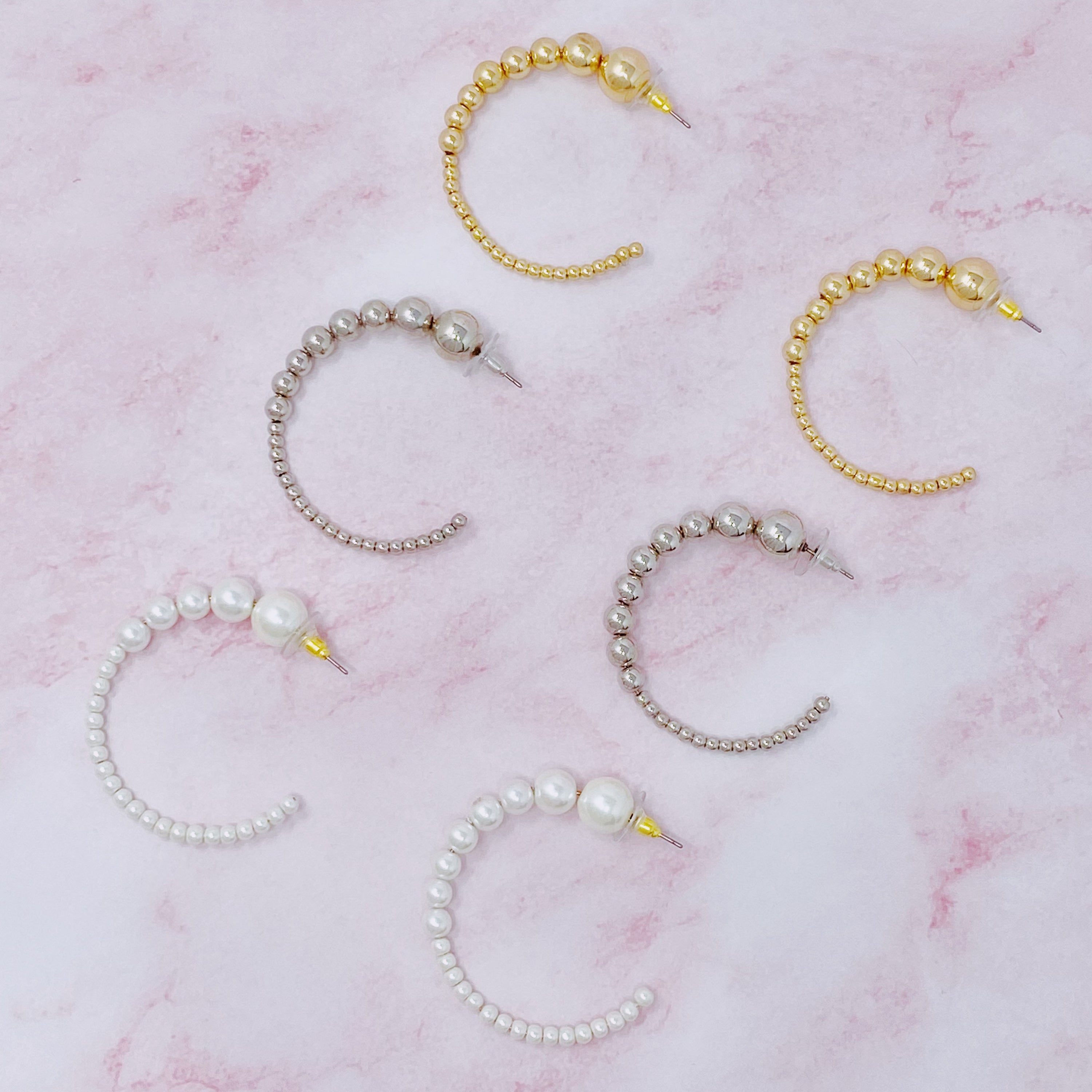 Stylish Gradation Bauble Hoop Earrings featuring a unique arrangement of large and small beads in a hoop design.