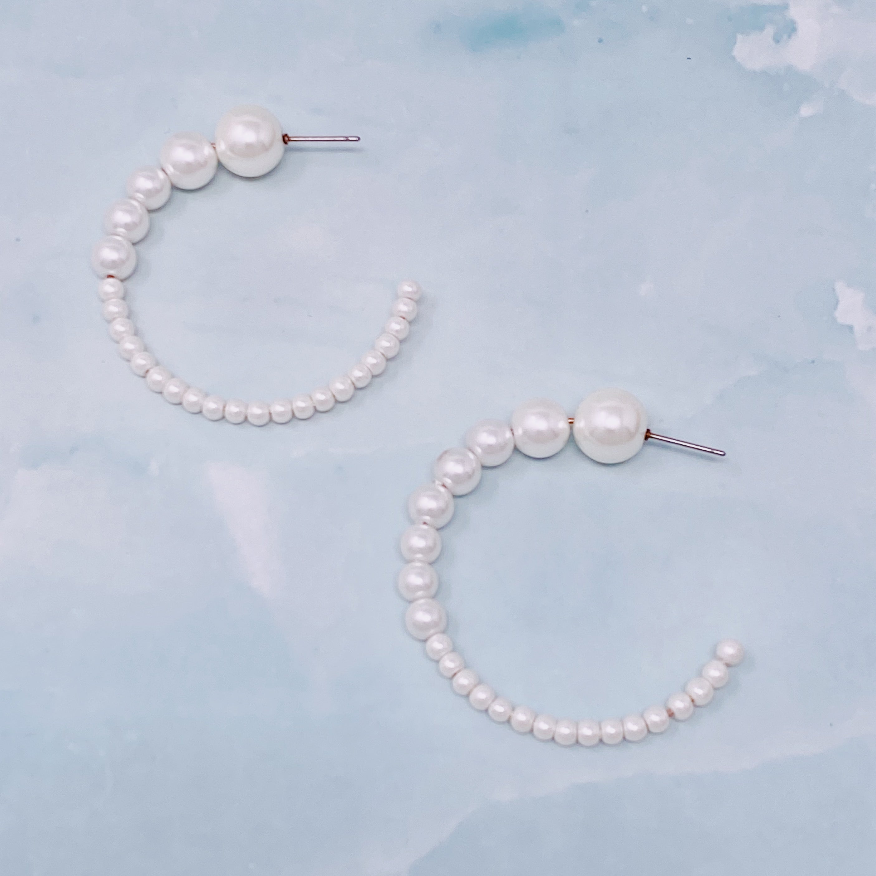 Stylish Gradation Bauble Hoop Earrings featuring a unique arrangement of large and small beads in a hoop design.