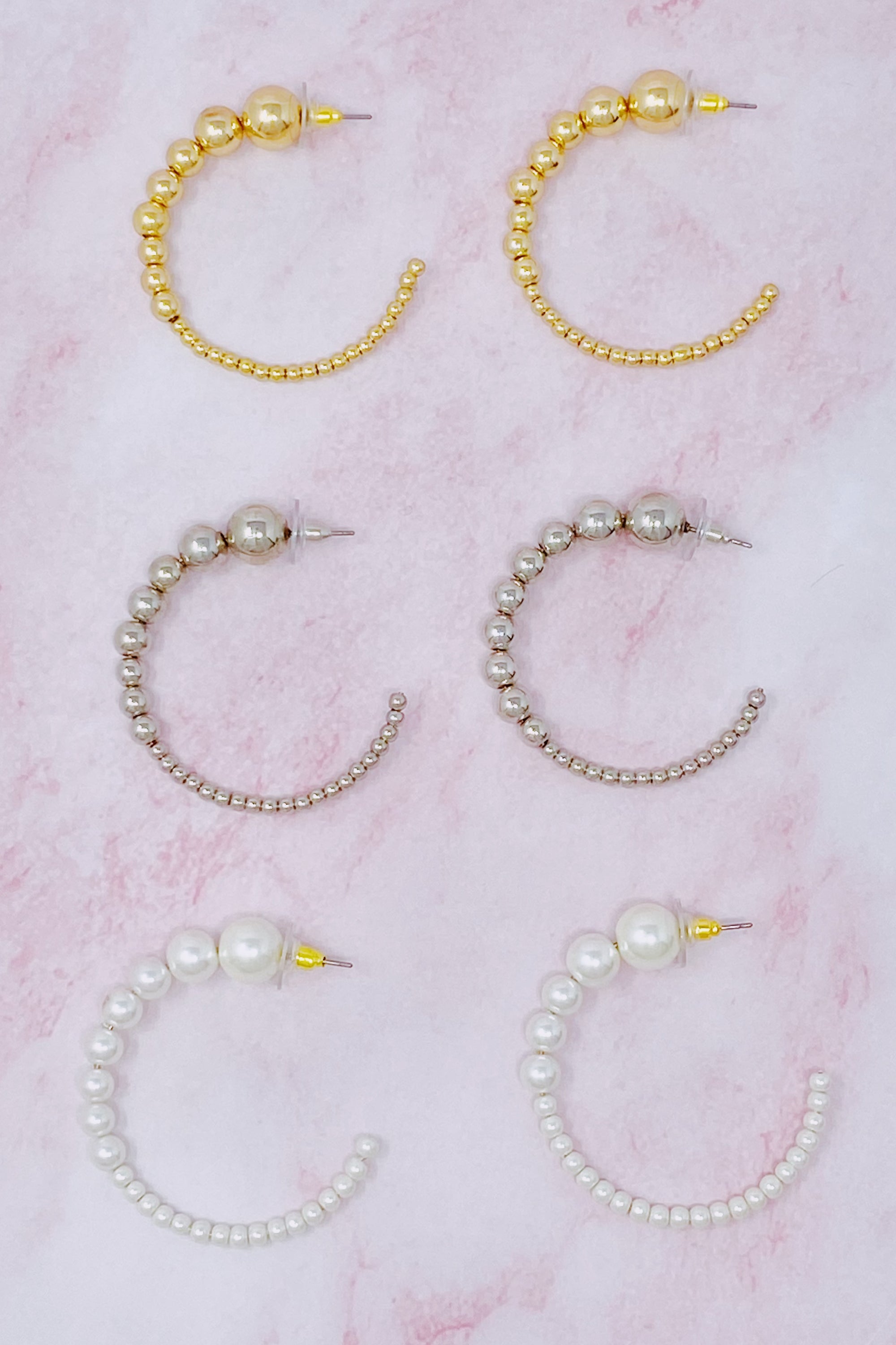 Stylish Gradation Bauble Hoop Earrings featuring a unique arrangement of large and small beads in a hoop design.