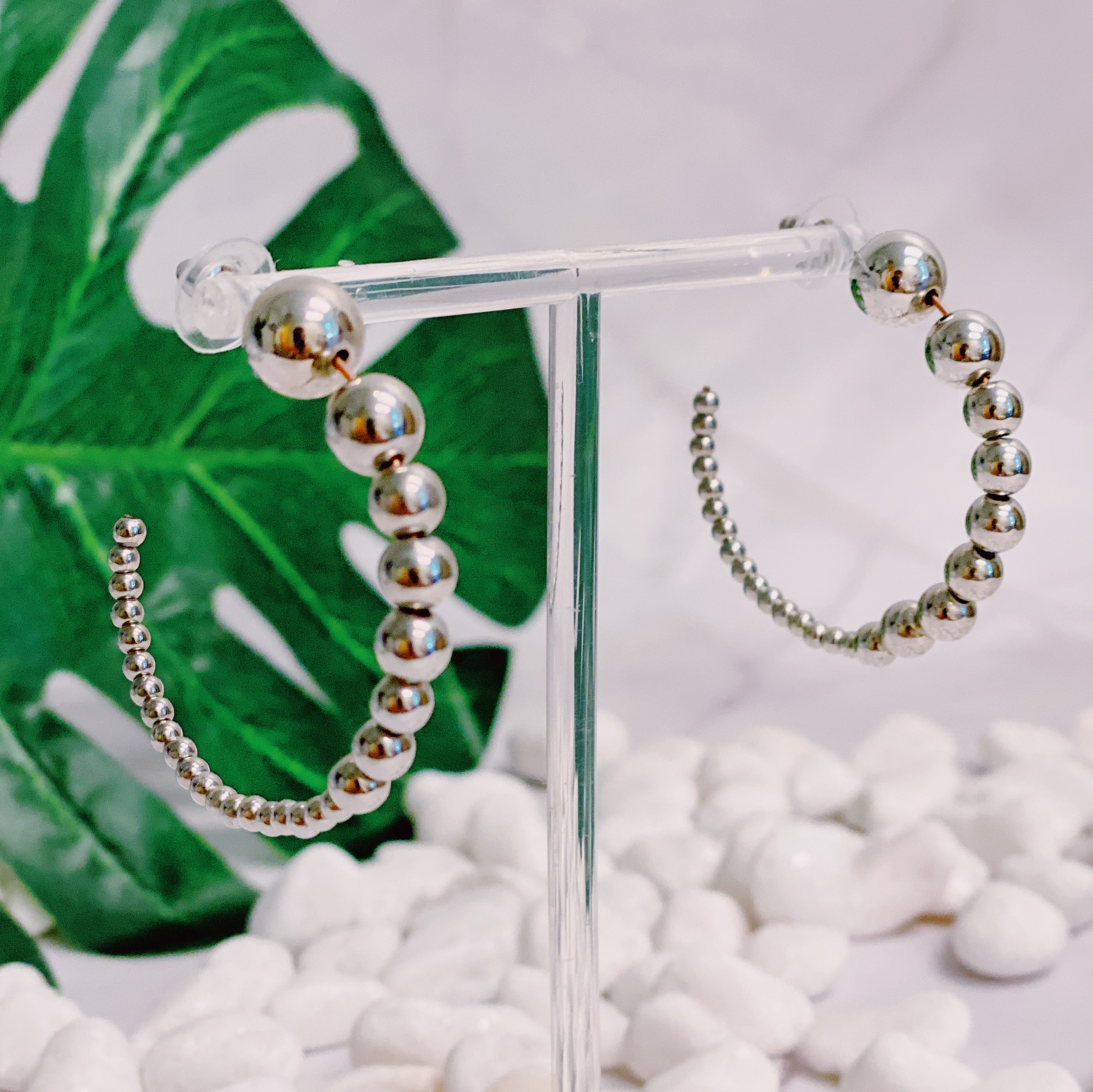 Stylish Gradation Bauble Hoop Earrings featuring a unique arrangement of large and small beads in a hoop design.