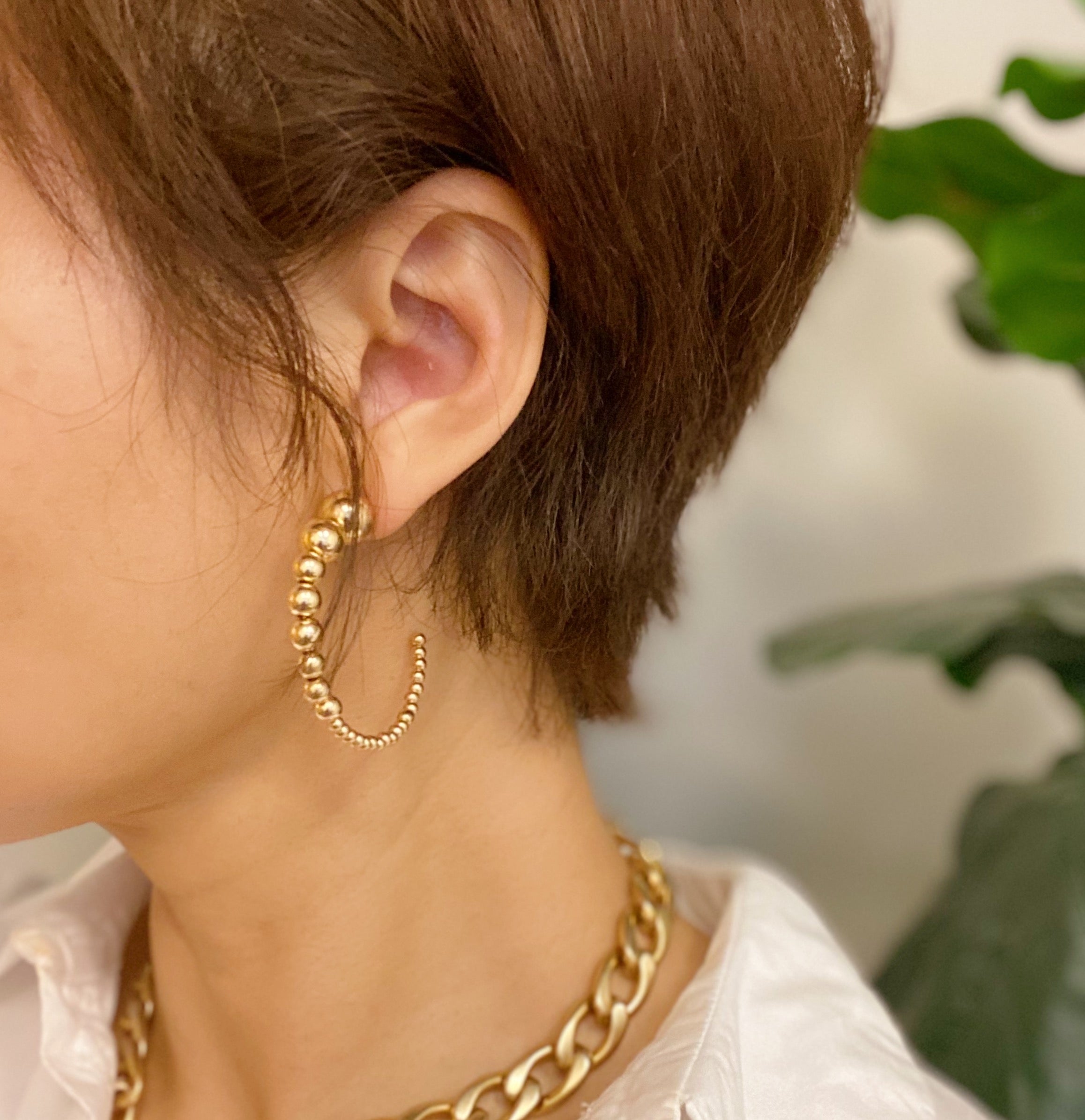 Stylish Gradation Bauble Hoop Earrings featuring a unique arrangement of large and small beads in a hoop design.