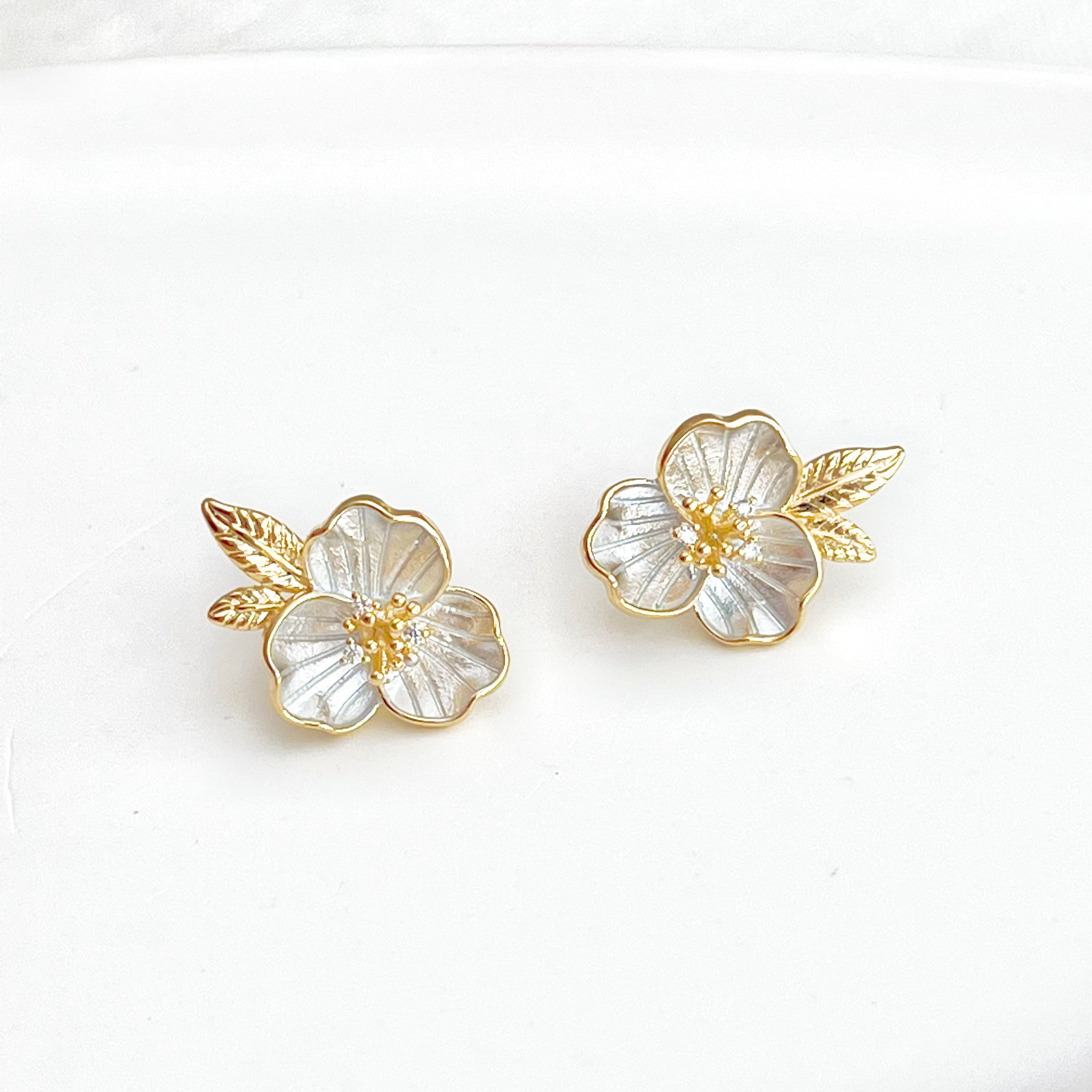 Gold flower earrings with leaves.