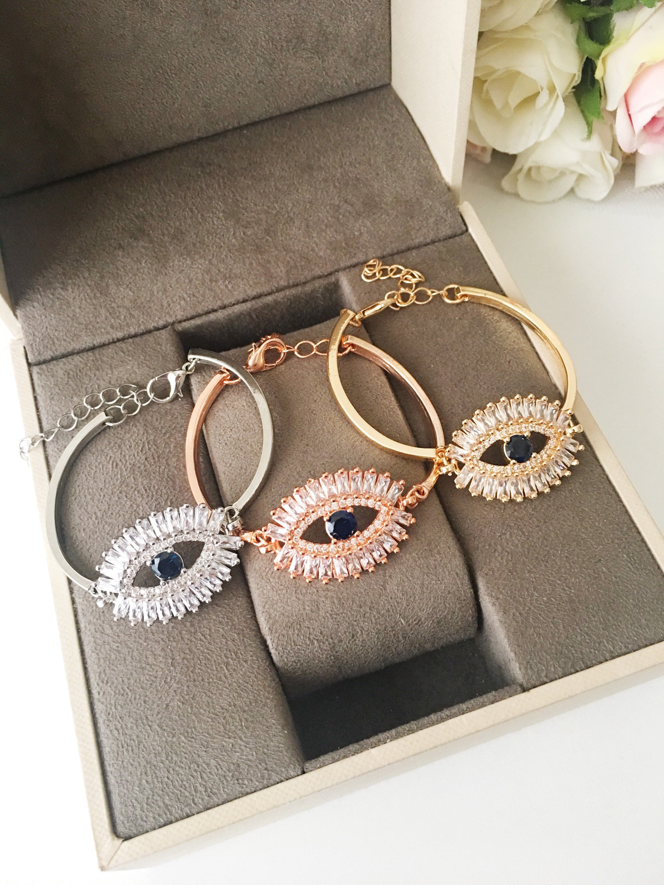 A beautiful Greek Evil Eye Bracelet featuring a sparkling cubic zirconia baguette design, available in silver, gold, and rose gold finishes.