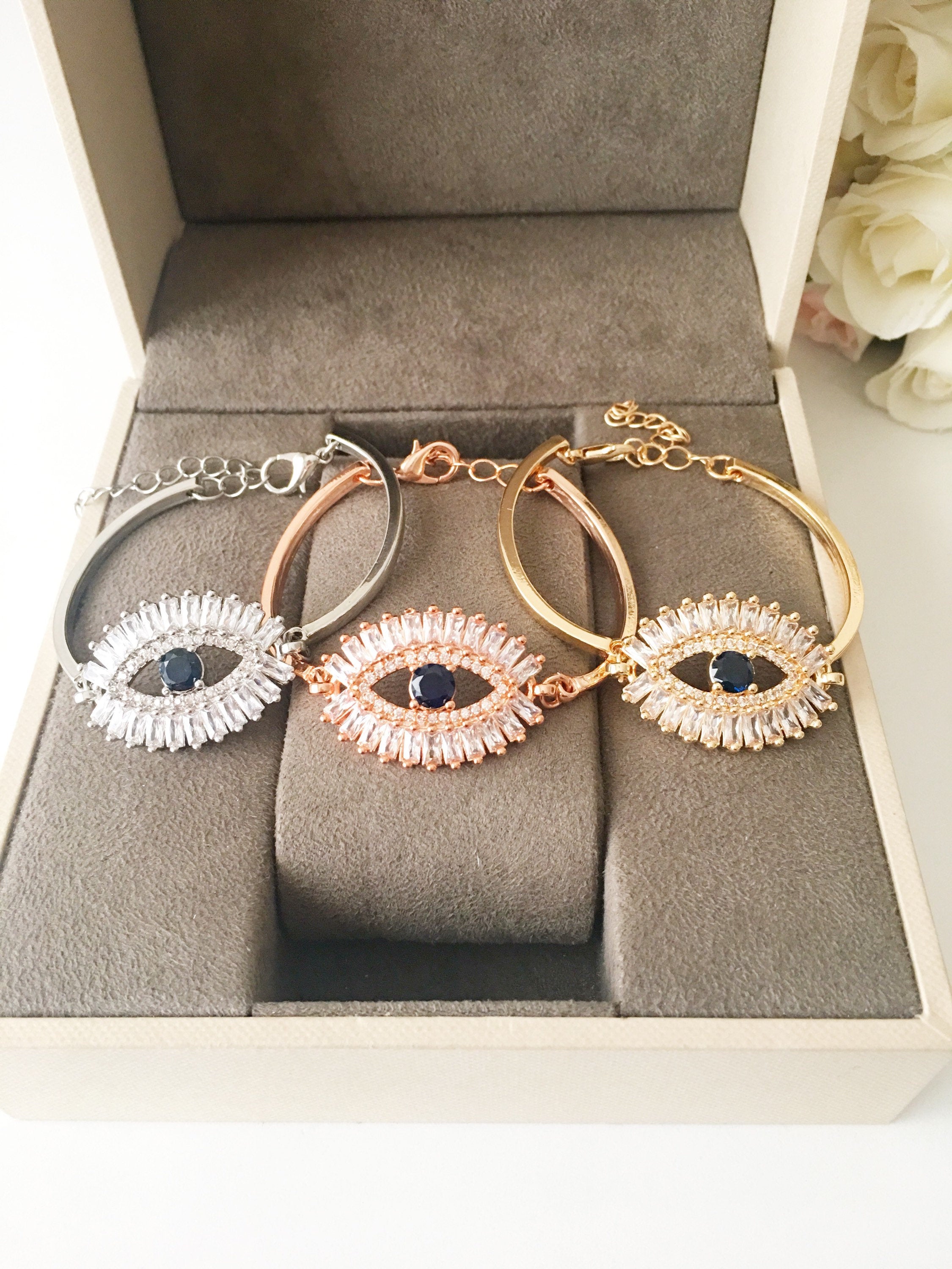 A beautiful Greek Evil Eye Bracelet featuring a sparkling cubic zirconia baguette design, available in silver, gold, and rose gold finishes.