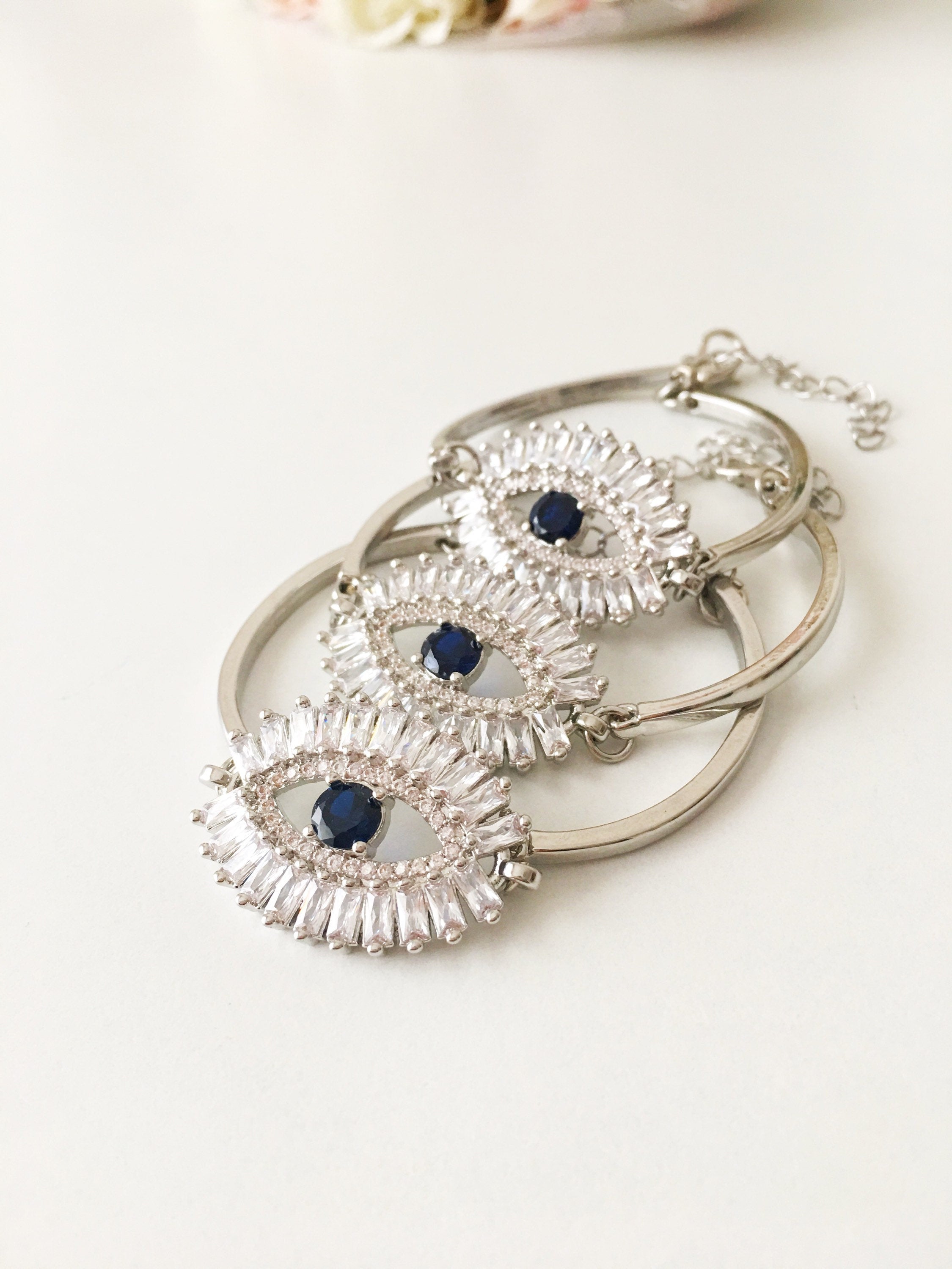 A beautiful Greek Evil Eye Bracelet featuring a sparkling cubic zirconia baguette design, available in silver, gold, and rose gold finishes.