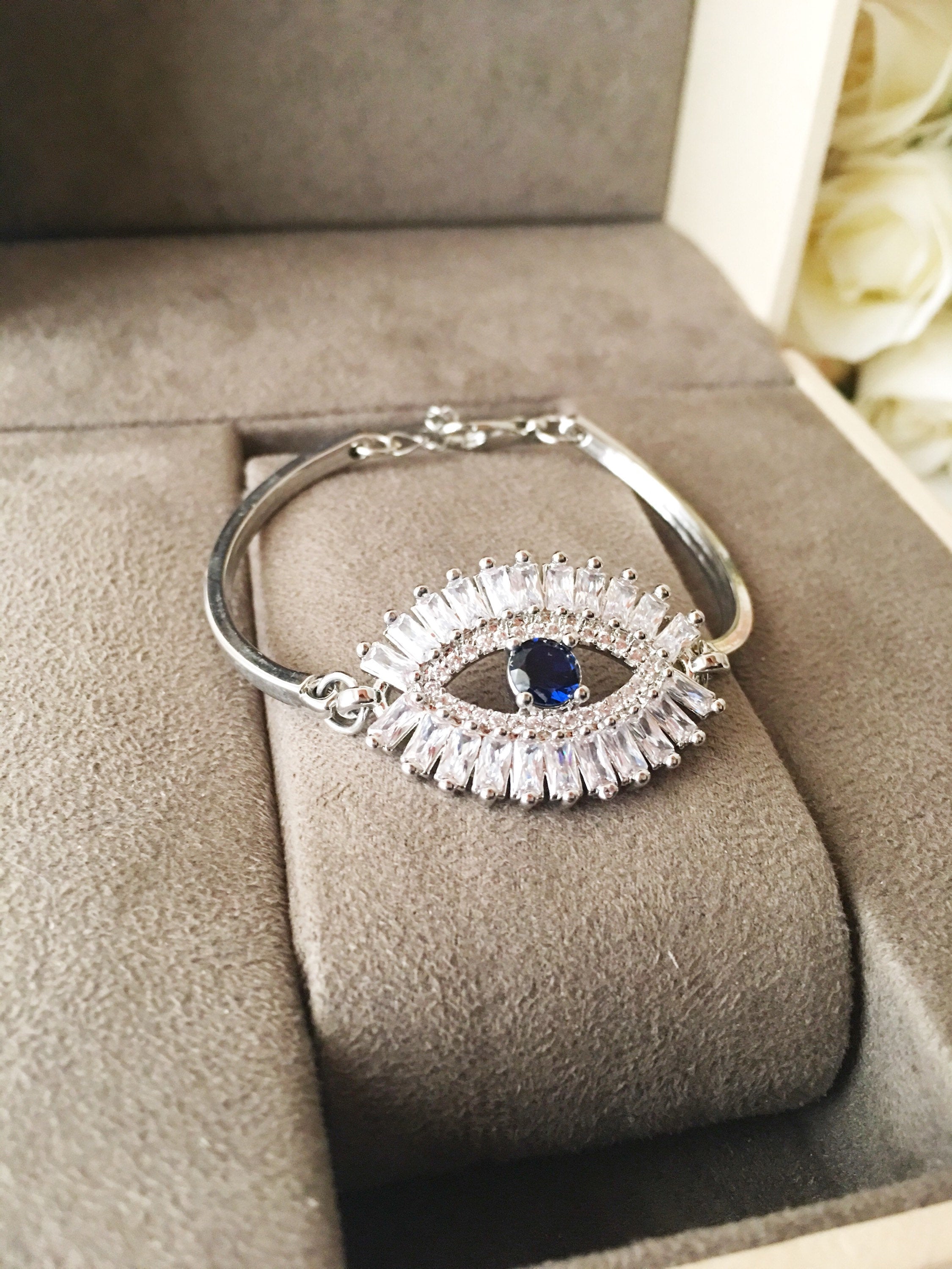 A beautiful Greek Evil Eye Bracelet featuring a sparkling cubic zirconia baguette design, available in silver, gold, and rose gold finishes.