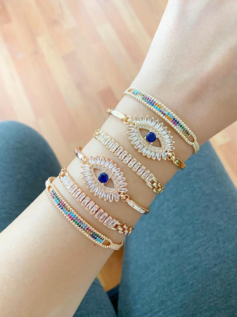 A beautiful Greek Evil Eye Bracelet featuring rainbow zircon stones, adjustable design, and available in rose gold and gold finishes.