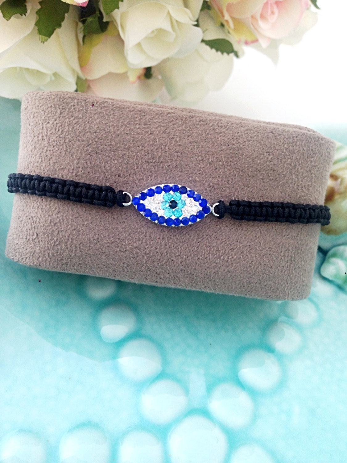 Handmade Greek Evil Eye Bracelet featuring an adjustable black macramé string and traditional evil eye charm, symbolizing protection and good luck.