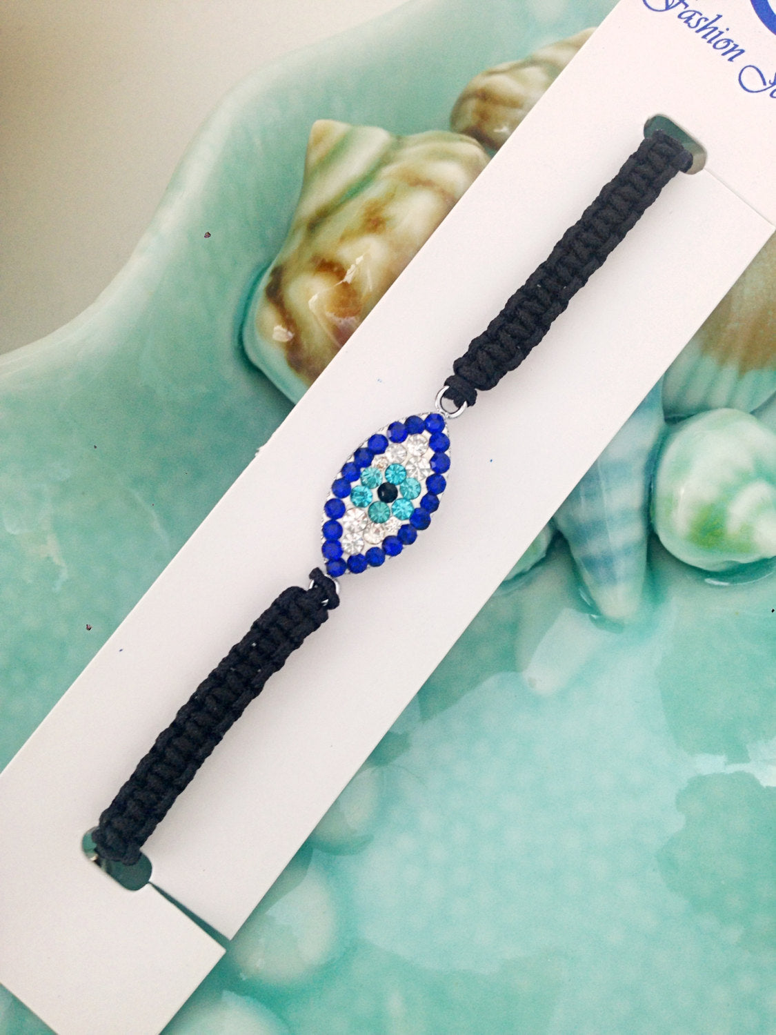 Handmade Greek Evil Eye Bracelet featuring an adjustable black macramé string and traditional evil eye charm, symbolizing protection and good luck.