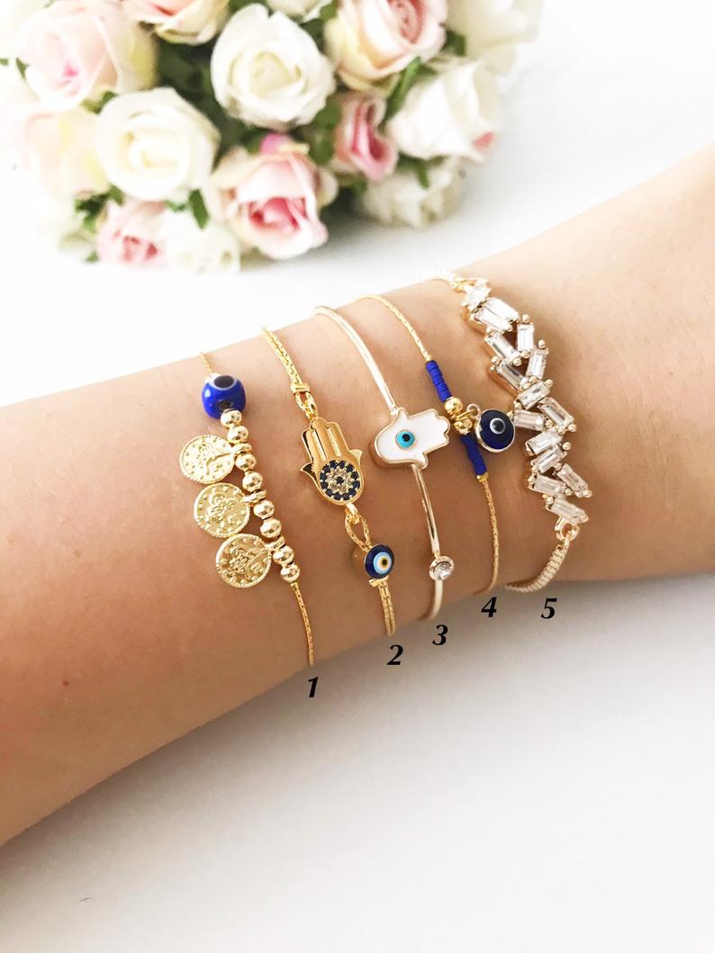 A stunning gold bangle bracelet featuring a blue evil eye bead, handcrafted from tarnish-resistant stainless steel.