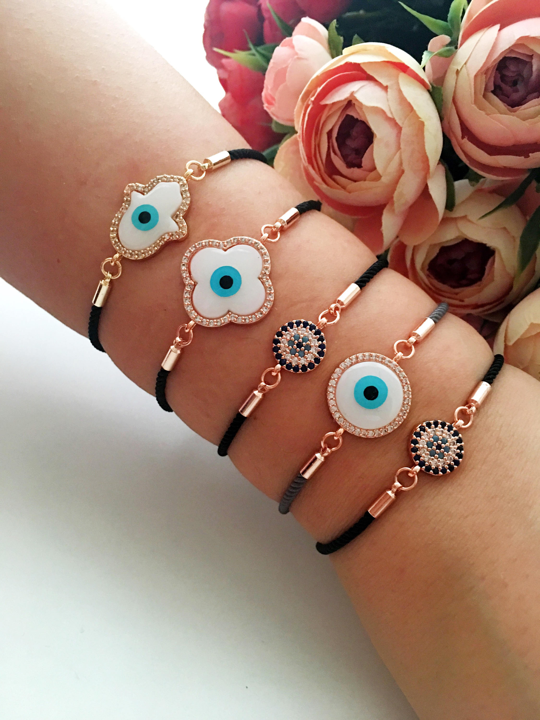 Handmade Greek Evil Eye Bracelet set in rose gold featuring Hamsa and Clover charms with zirconia accents.