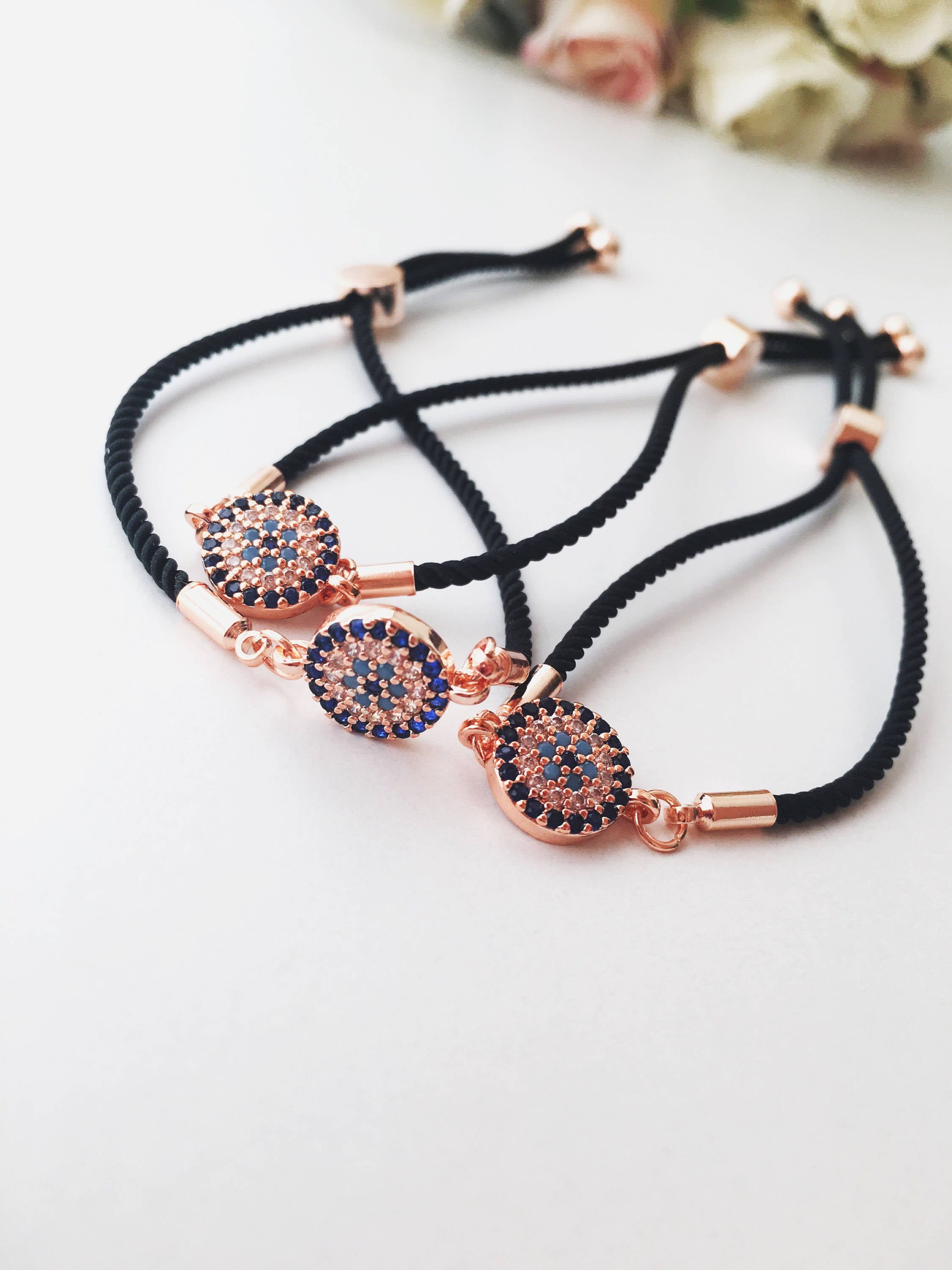 Handmade Greek Evil Eye Bracelet set in rose gold featuring Hamsa and Clover charms with zirconia accents.