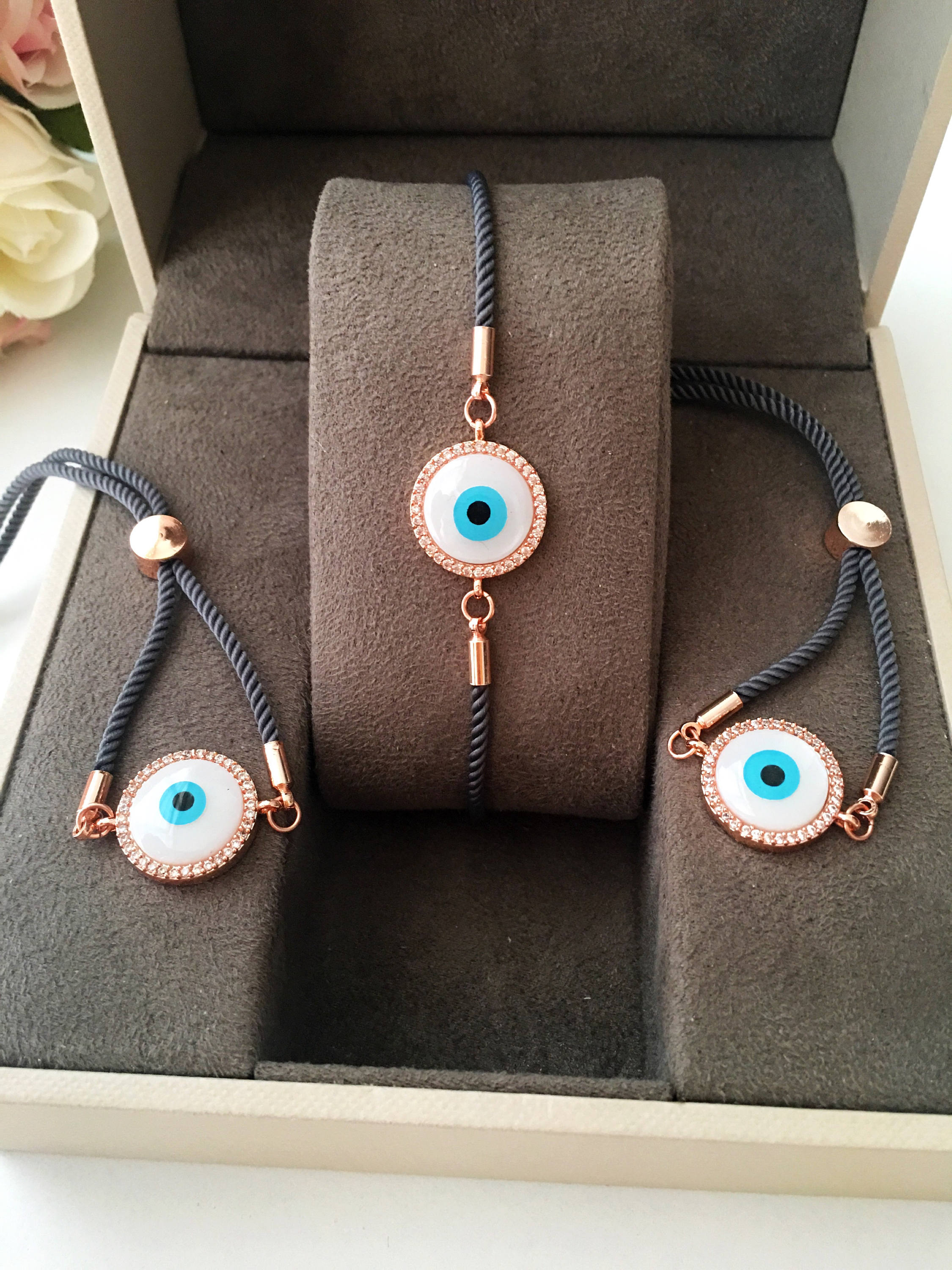 Handmade Greek Evil Eye Bracelet set in rose gold featuring Hamsa and Clover charms with zirconia accents.