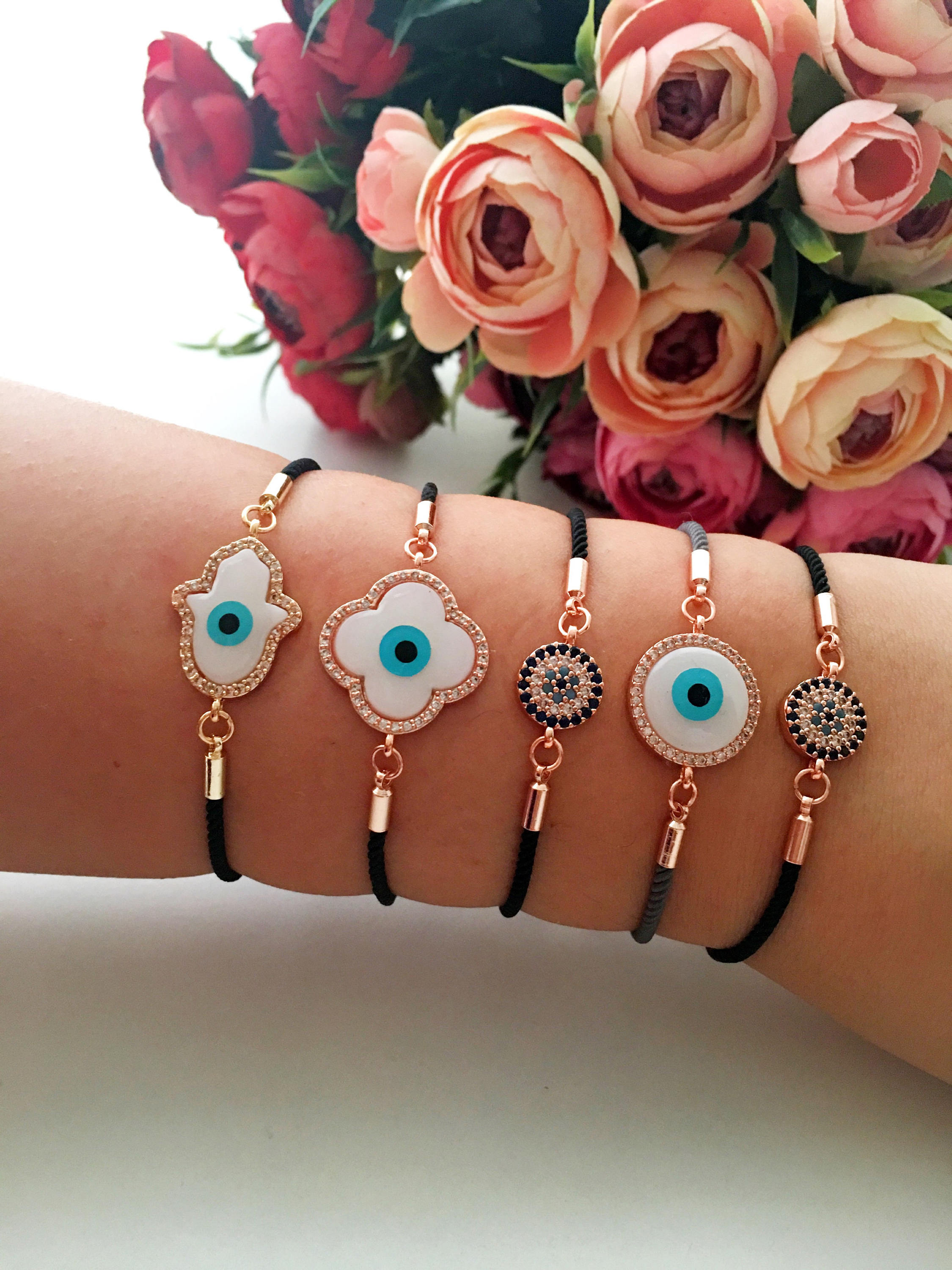 Handmade Greek Evil Eye Bracelet set in rose gold featuring Hamsa and Clover charms with zirconia accents.