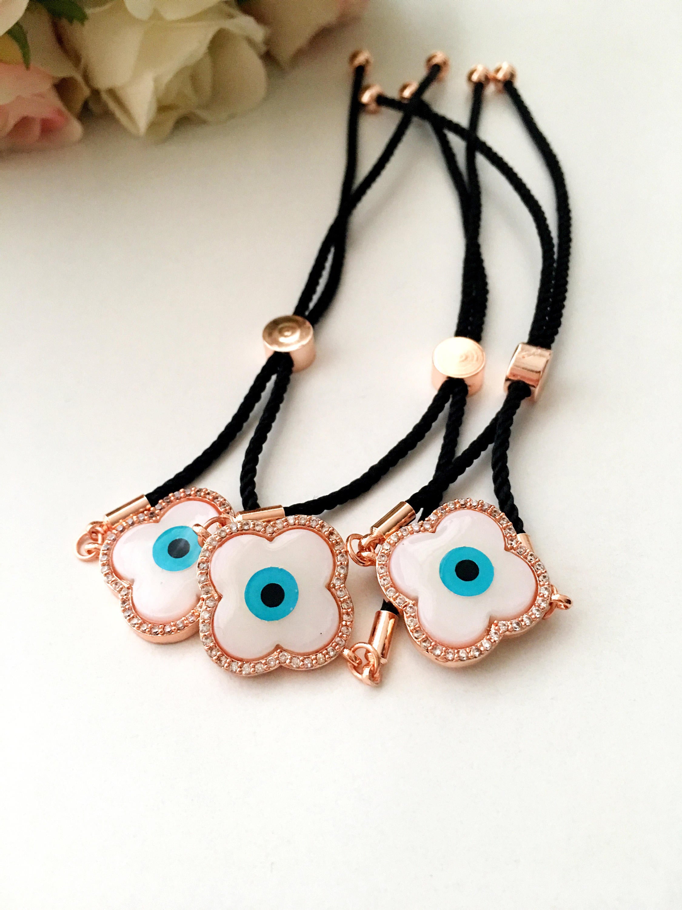 Handmade Greek Evil Eye Bracelet set in rose gold featuring Hamsa and Clover charms with zirconia accents.