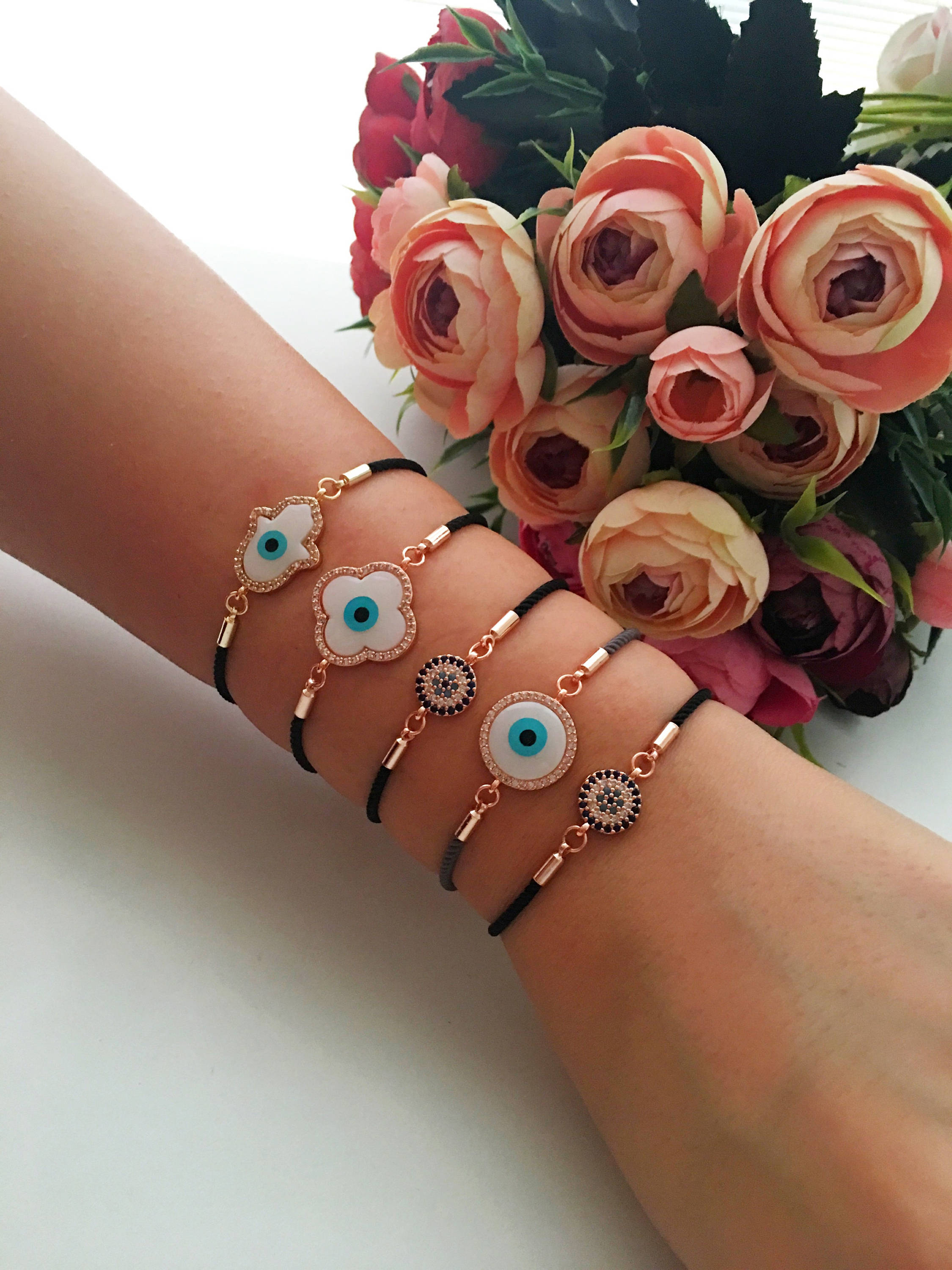 Handmade Greek Evil Eye Bracelet set in rose gold featuring Hamsa and Clover charms with zirconia accents.