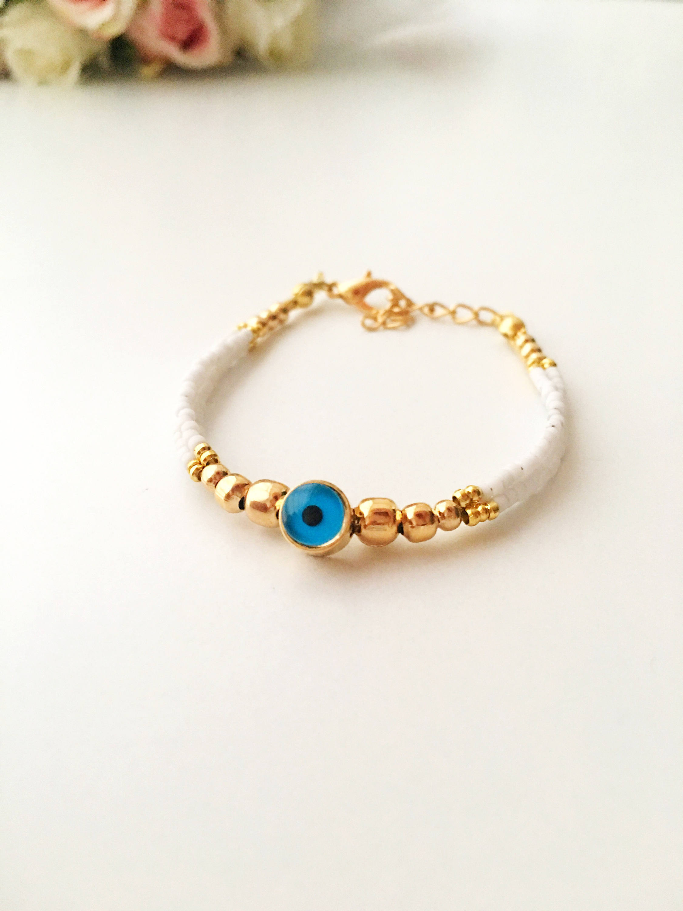 Handmade Greek Evil Eye Bracelet featuring vibrant seed beads and gold accents, available in turquoise, dark blue, red, and white.