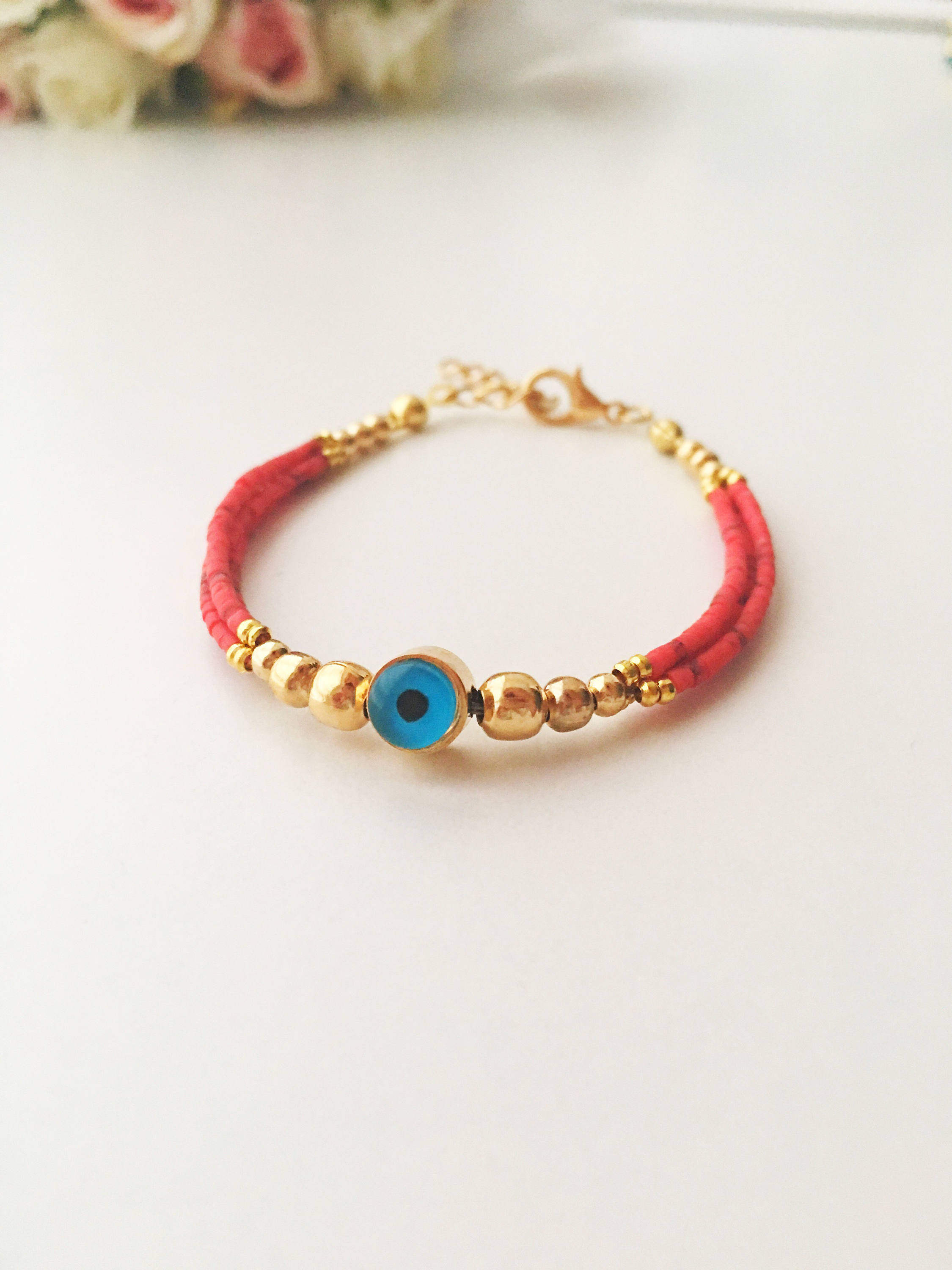 Handmade Greek Evil Eye Bracelet featuring vibrant seed beads and gold accents, available in turquoise, dark blue, red, and white.