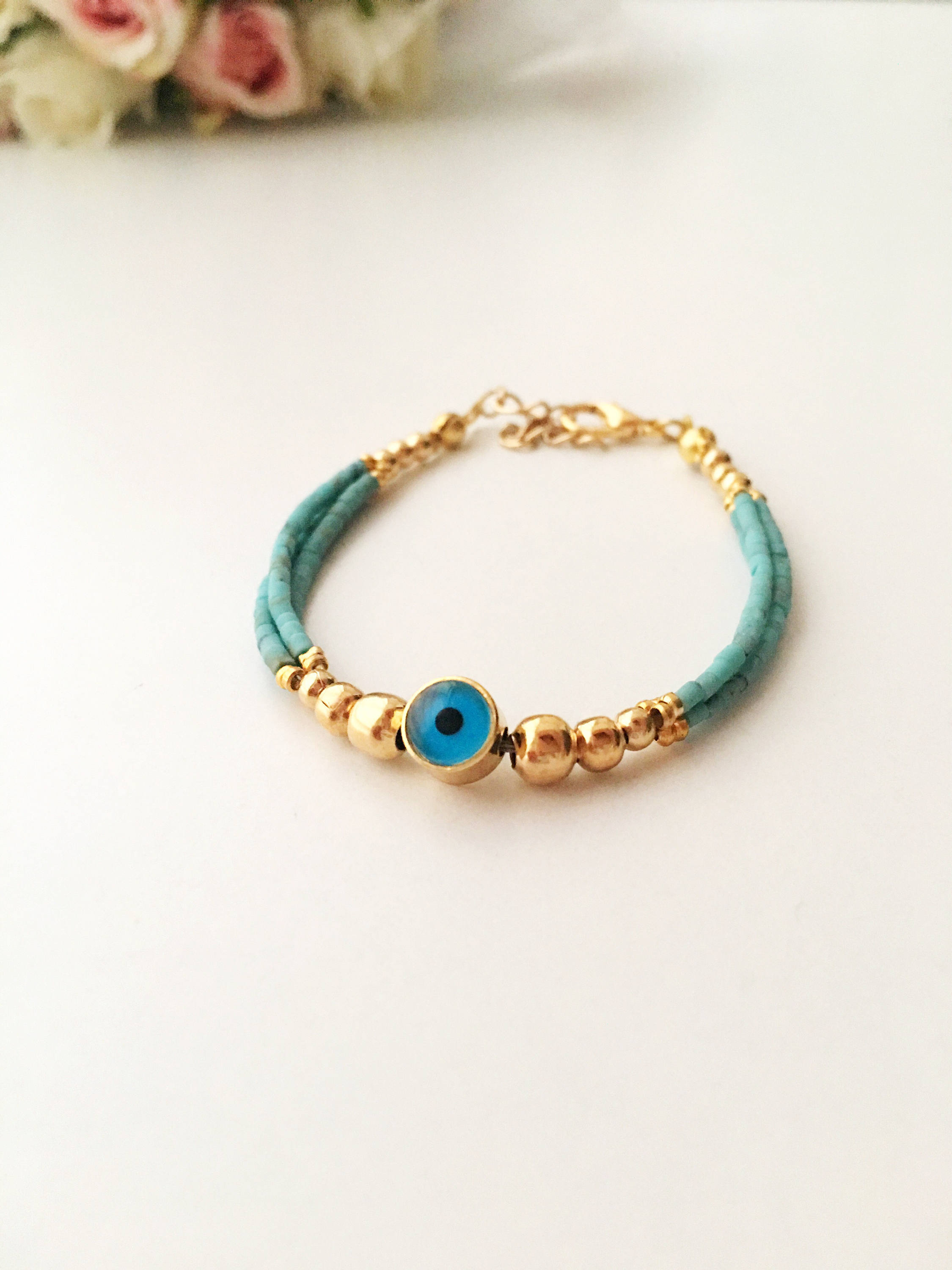 Handmade Greek Evil Eye Bracelet featuring vibrant seed beads and gold accents, available in turquoise, dark blue, red, and white.