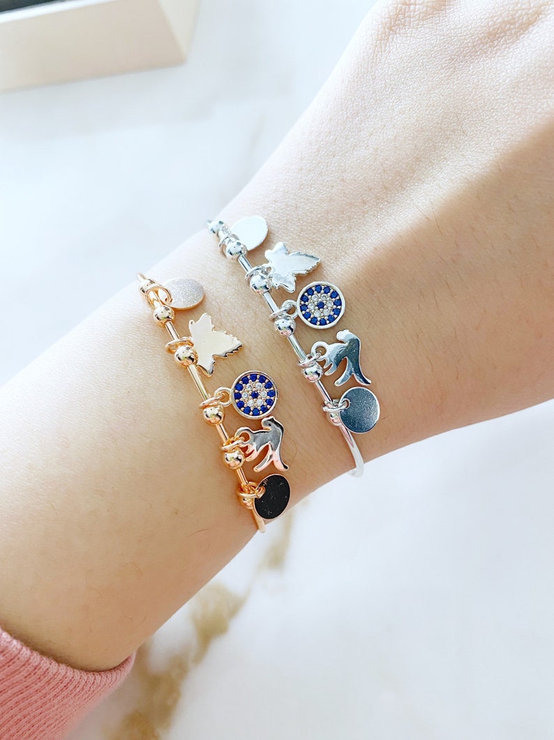 A stunning Greek Evil Eye Cuff Bracelet featuring a silver and rose finish, adorned with an evil eye charm for protection.