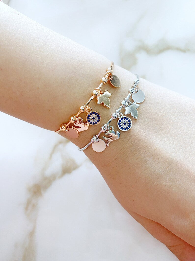 A stunning Greek Evil Eye Cuff Bracelet featuring a silver and rose finish, adorned with an evil eye charm for protection.