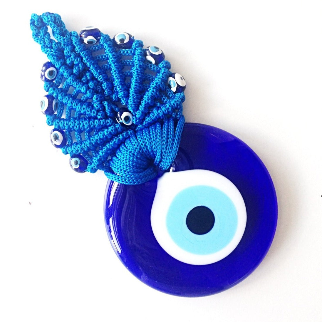 A beautifully handcrafted Greek Evil Eye Macrame Wall Hanging featuring a blue evil eye charm, intricately woven with macrame techniques.