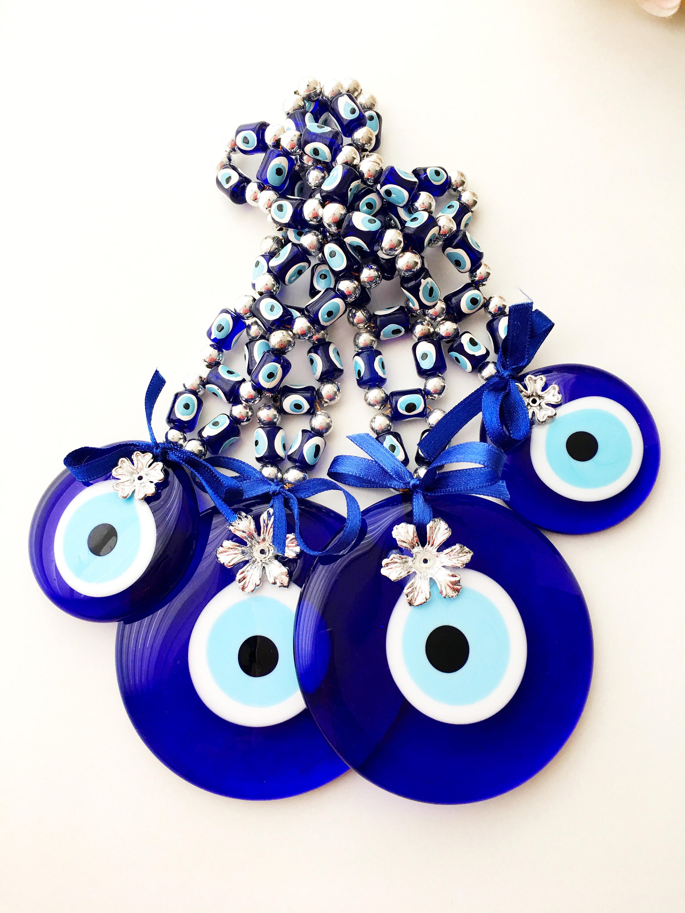 A beautifully crafted Greek Evil Eye Wall Hanging featuring large and small blue evil eye beads, symbolizing protection and good luck.