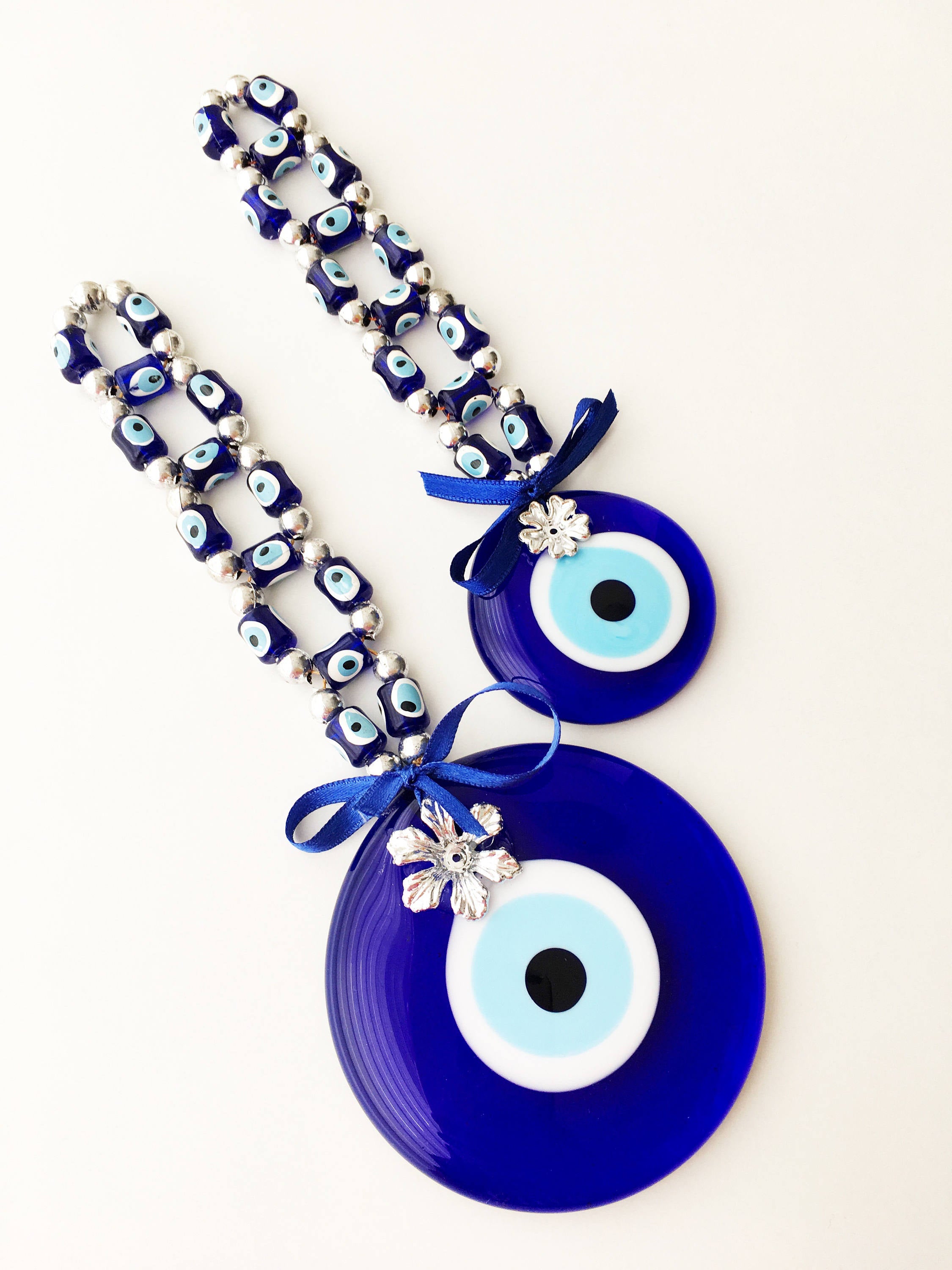 A beautifully crafted Greek Evil Eye Wall Hanging featuring large and small blue evil eye beads, symbolizing protection and good luck.