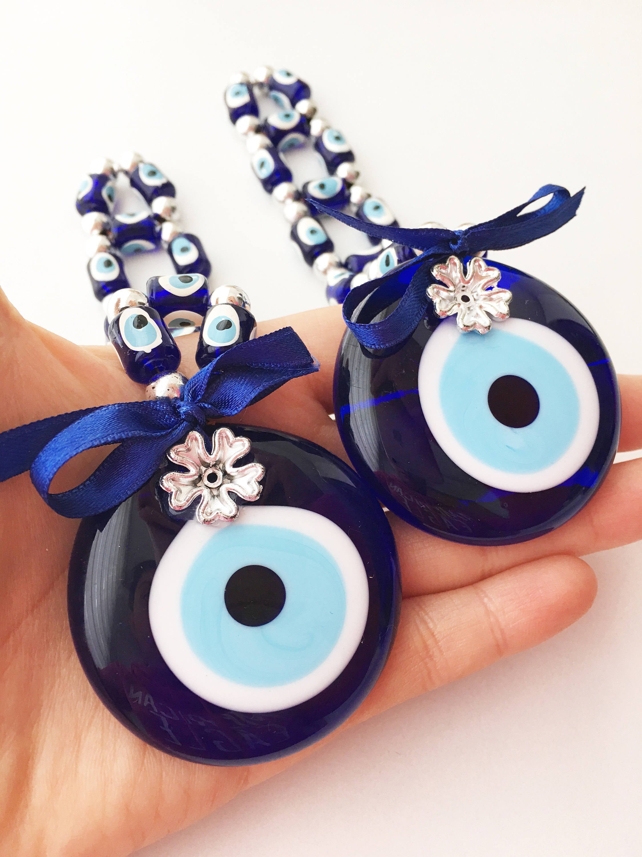 A beautifully crafted Greek Evil Eye Wall Hanging featuring large and small blue evil eye beads, symbolizing protection and good luck.